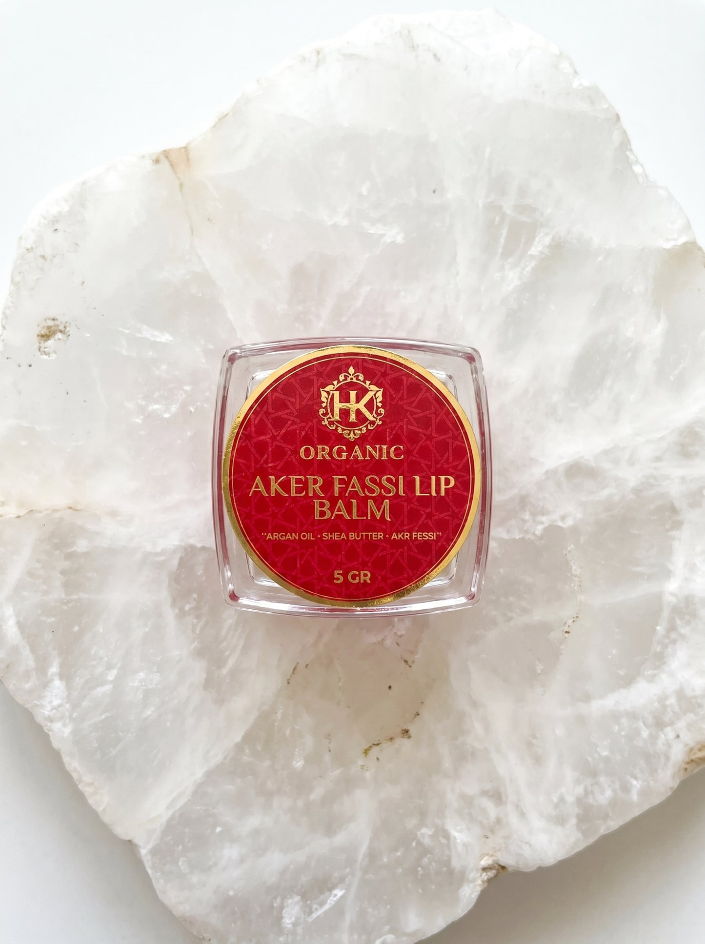 Organic Aker Fassli lip balm on a white stone surface
