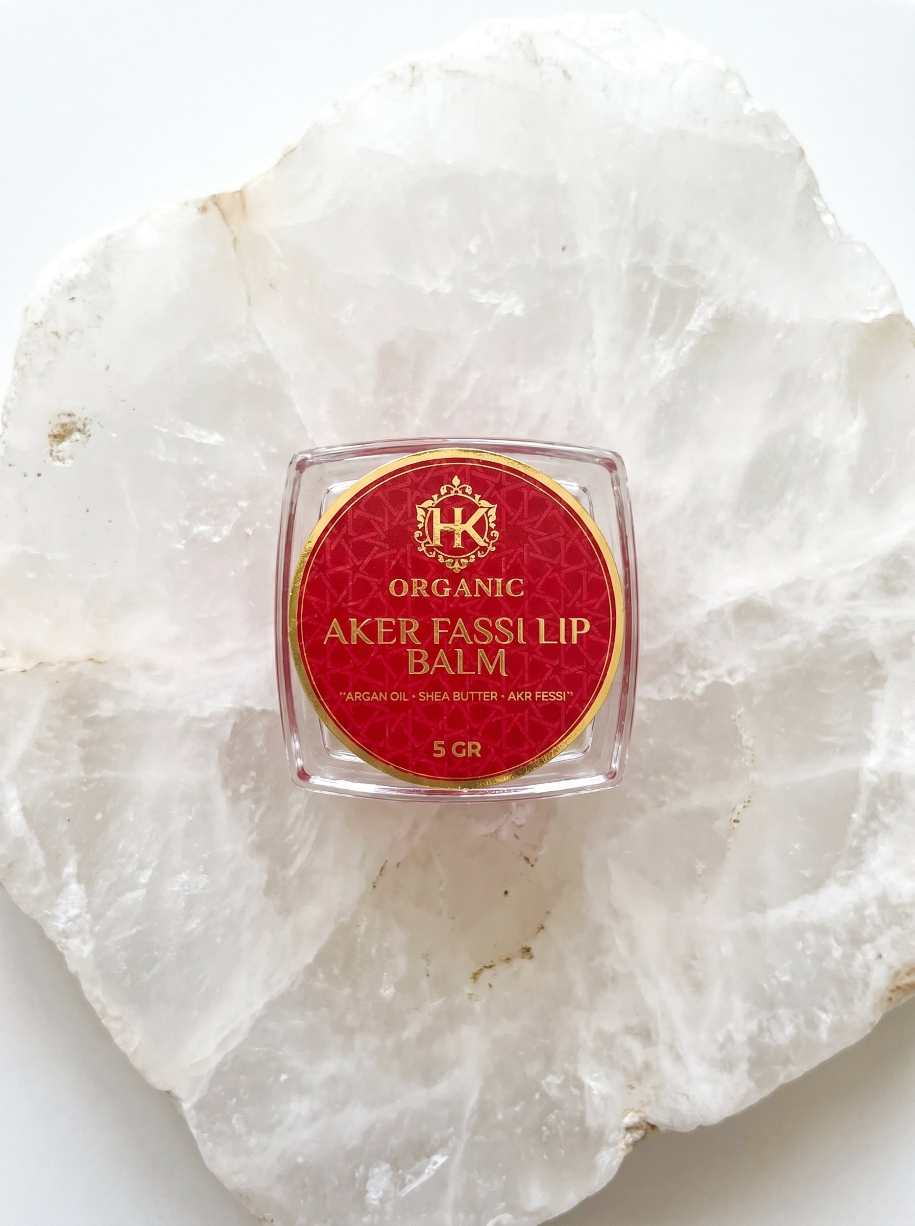 Organic Aker Fassli lip balm on a white stone surface
