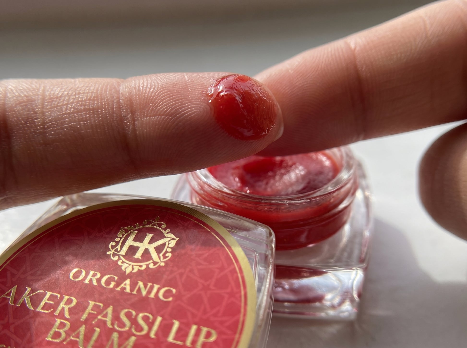 Organic lip balm with a person applying it to their finger