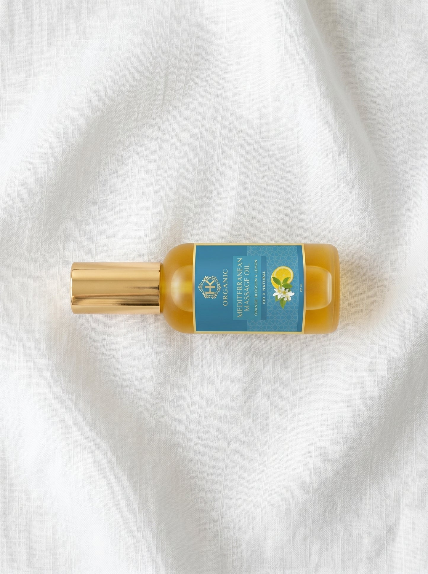 Small bottle with a gold cap and blue label on a white fabric background