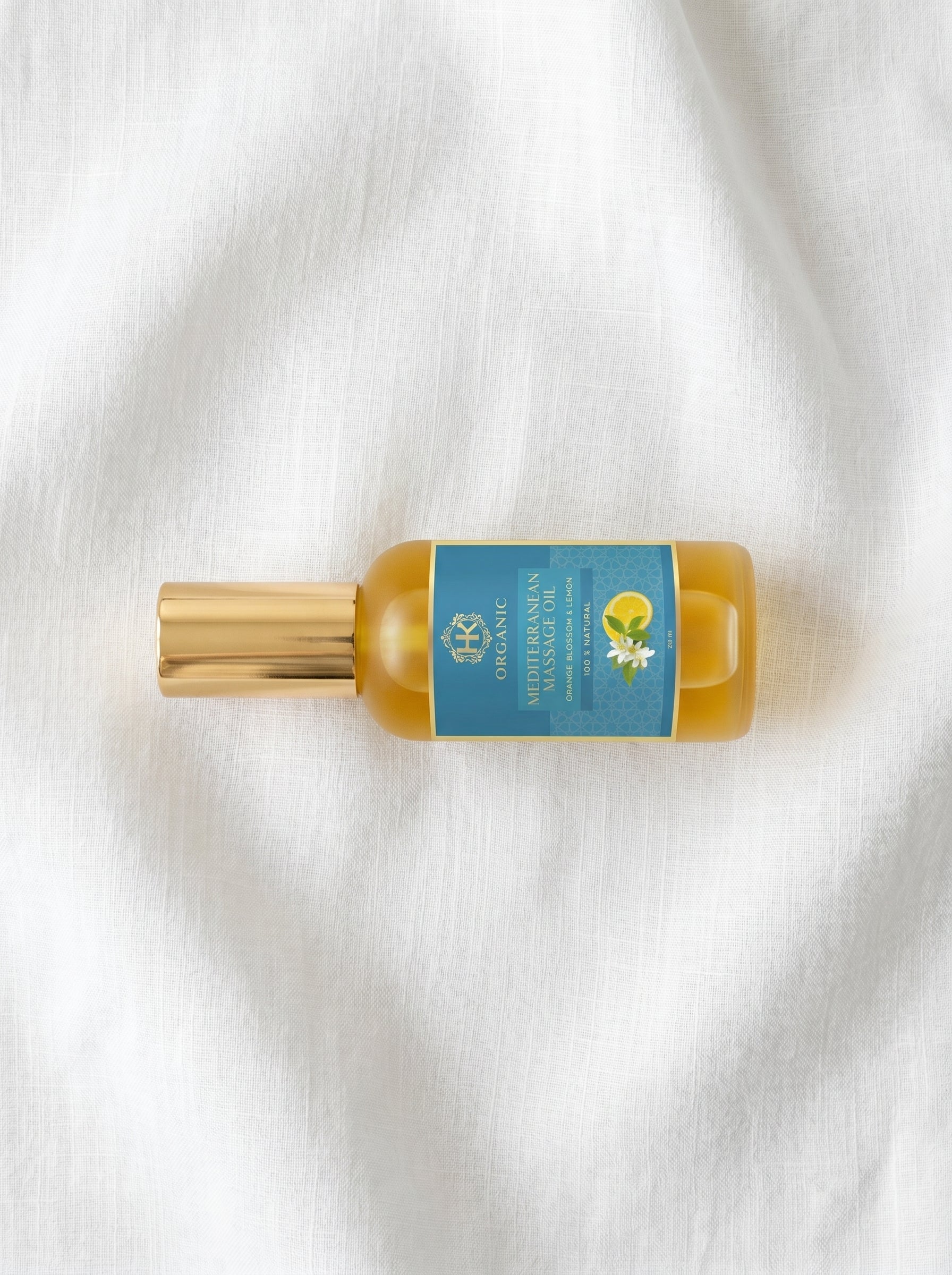 Small bottle with a gold cap and blue label on a white fabric background