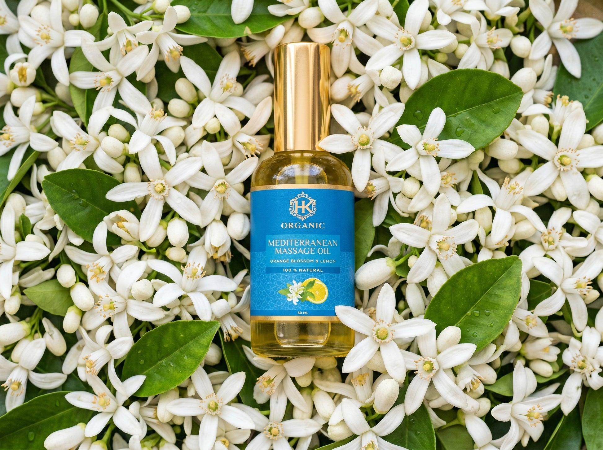 Massage oil bottle with blue label on a bed of white flowers and green leaves