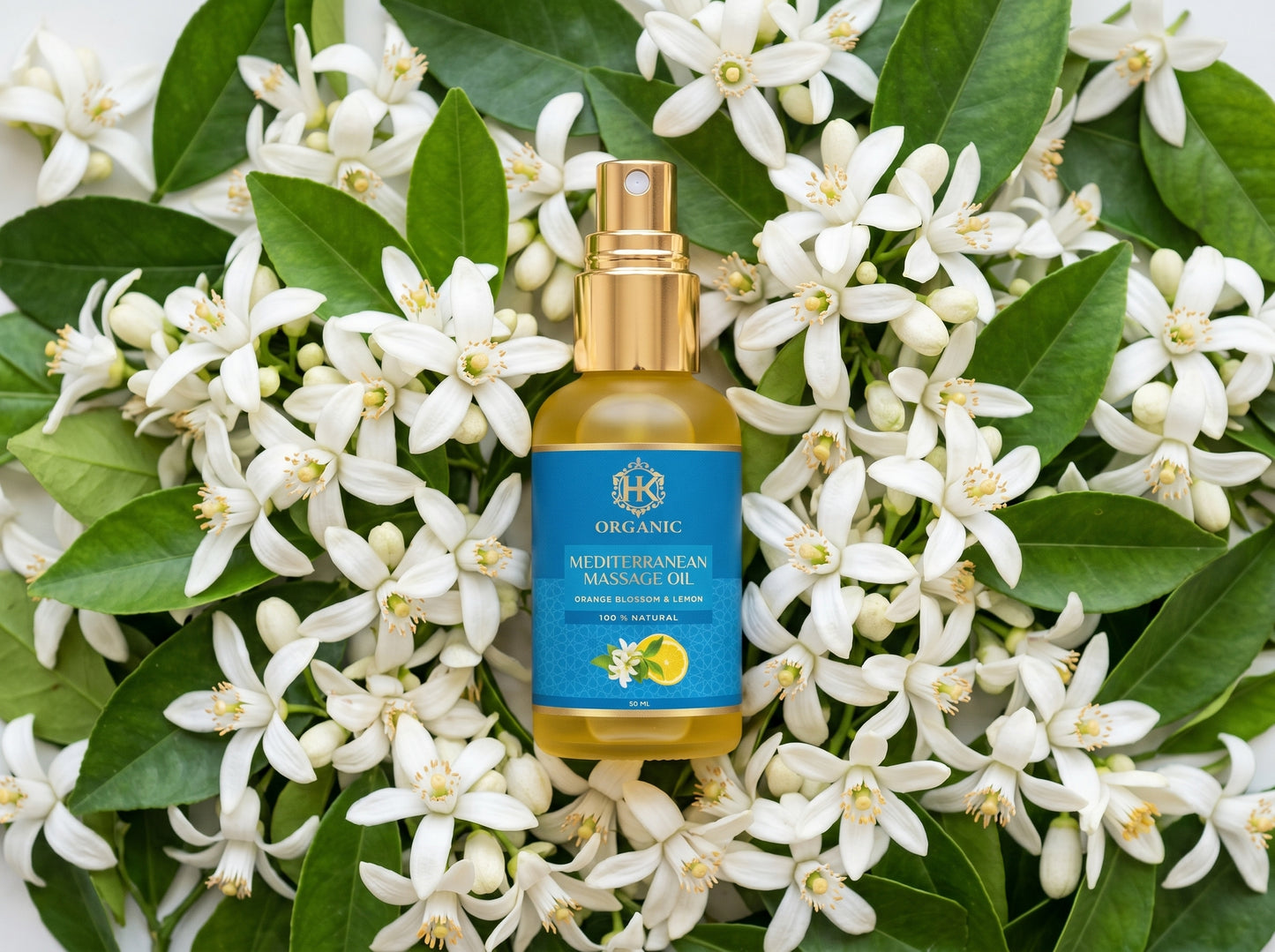 Bottle of organic Mediterranean mango oil surrounded by white flowers and green leaves