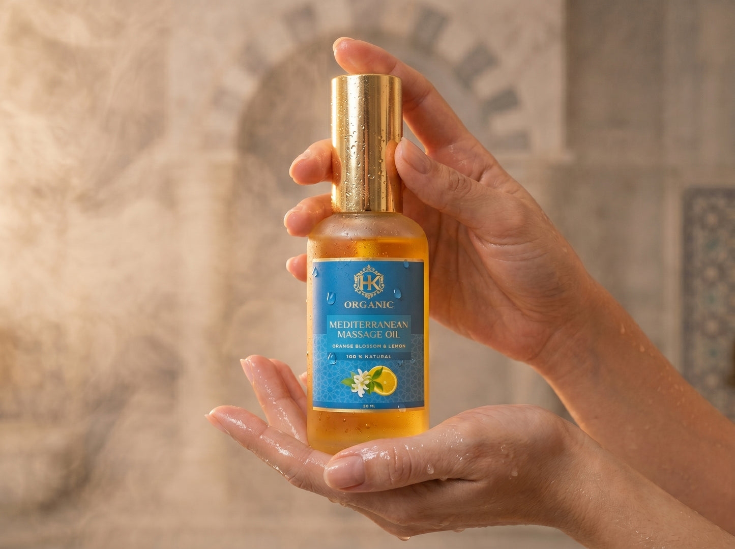 Hand holding a bottle of organic mertle orange massage oil with a decorative background