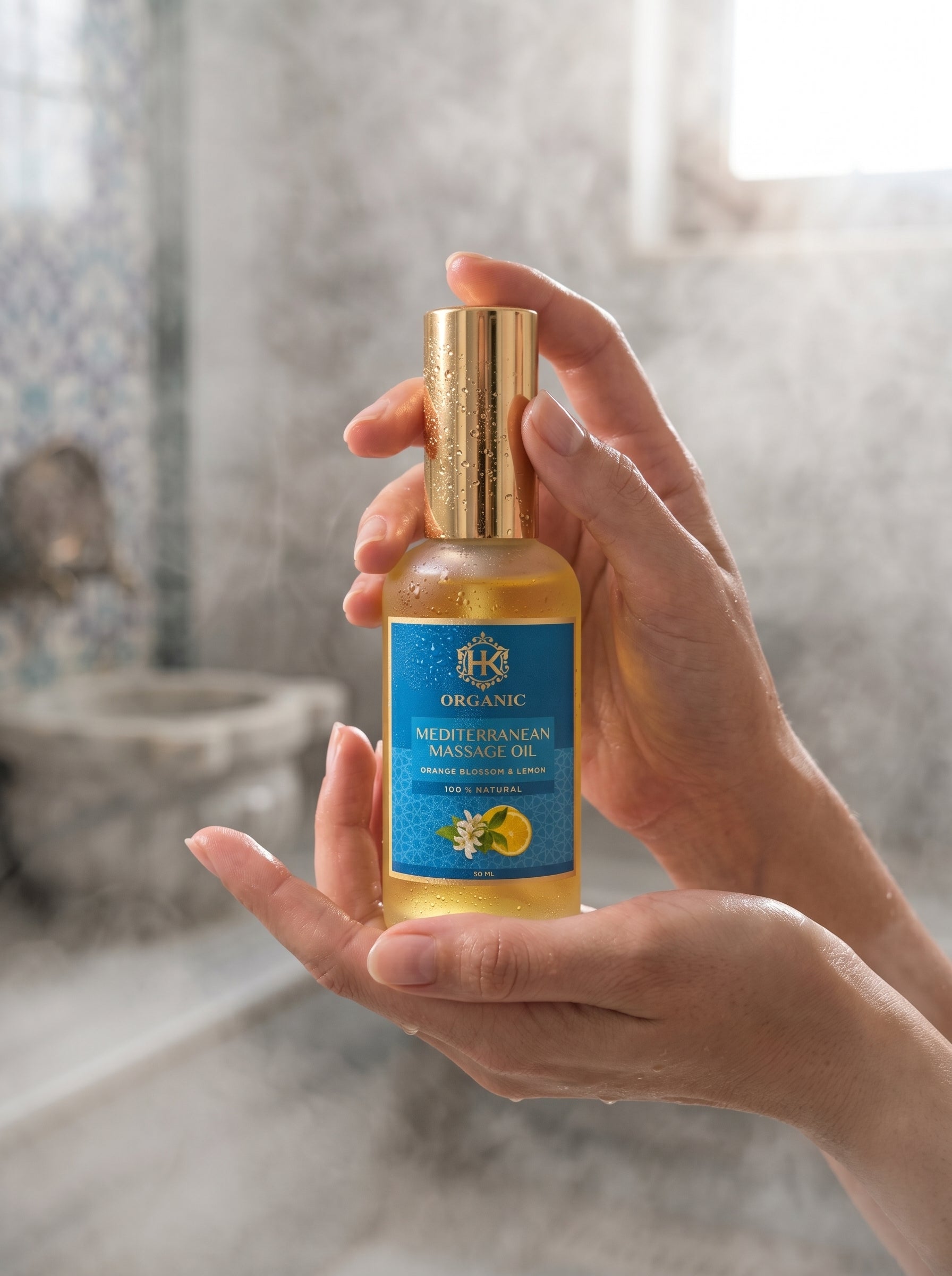 Hand holding a bottle of organic Mediterranean massage oil with a blurred background