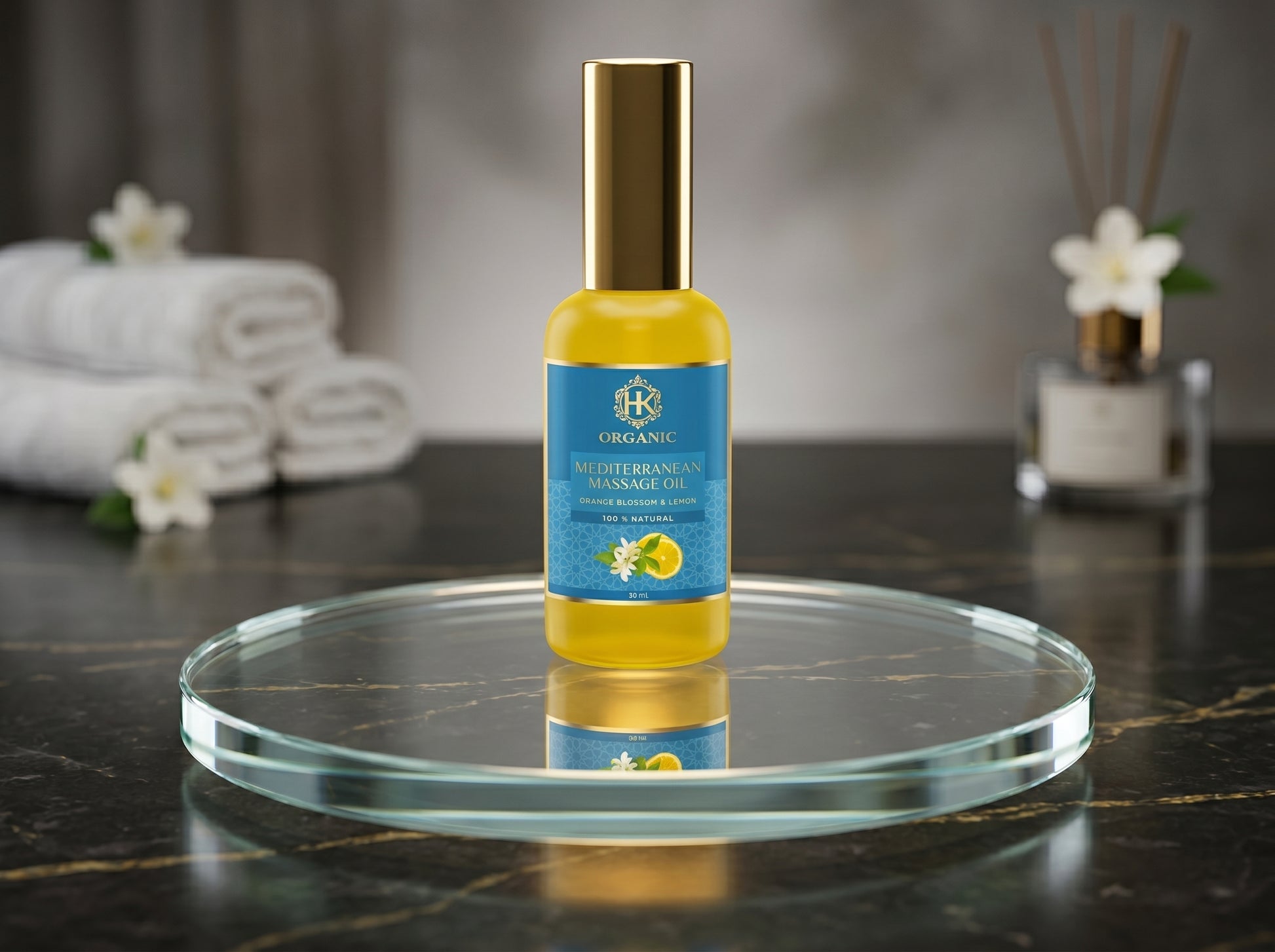 Massage oil bottle on a round glass tray with towels and diffuser in the background