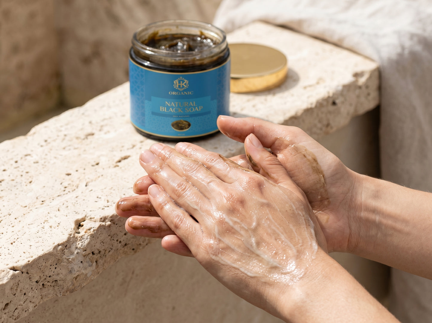Person applying soap to hands with a jar of soap in the background