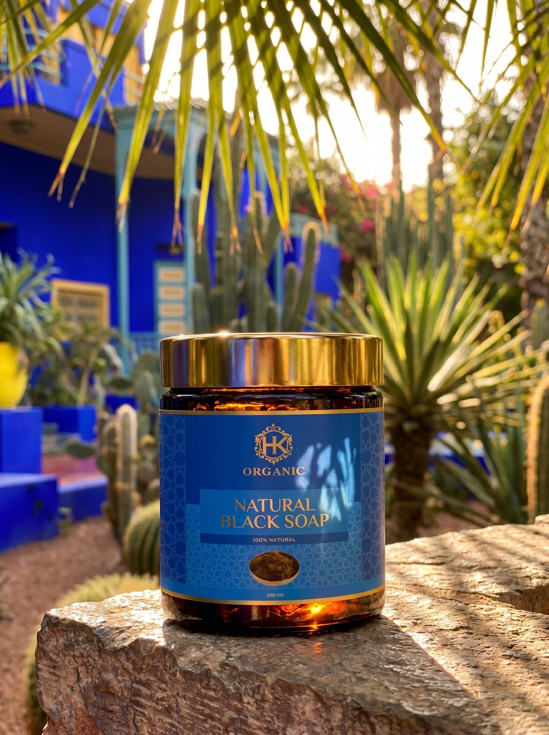 Jar of natural black soap with a gold lid on a rock in a garden setting