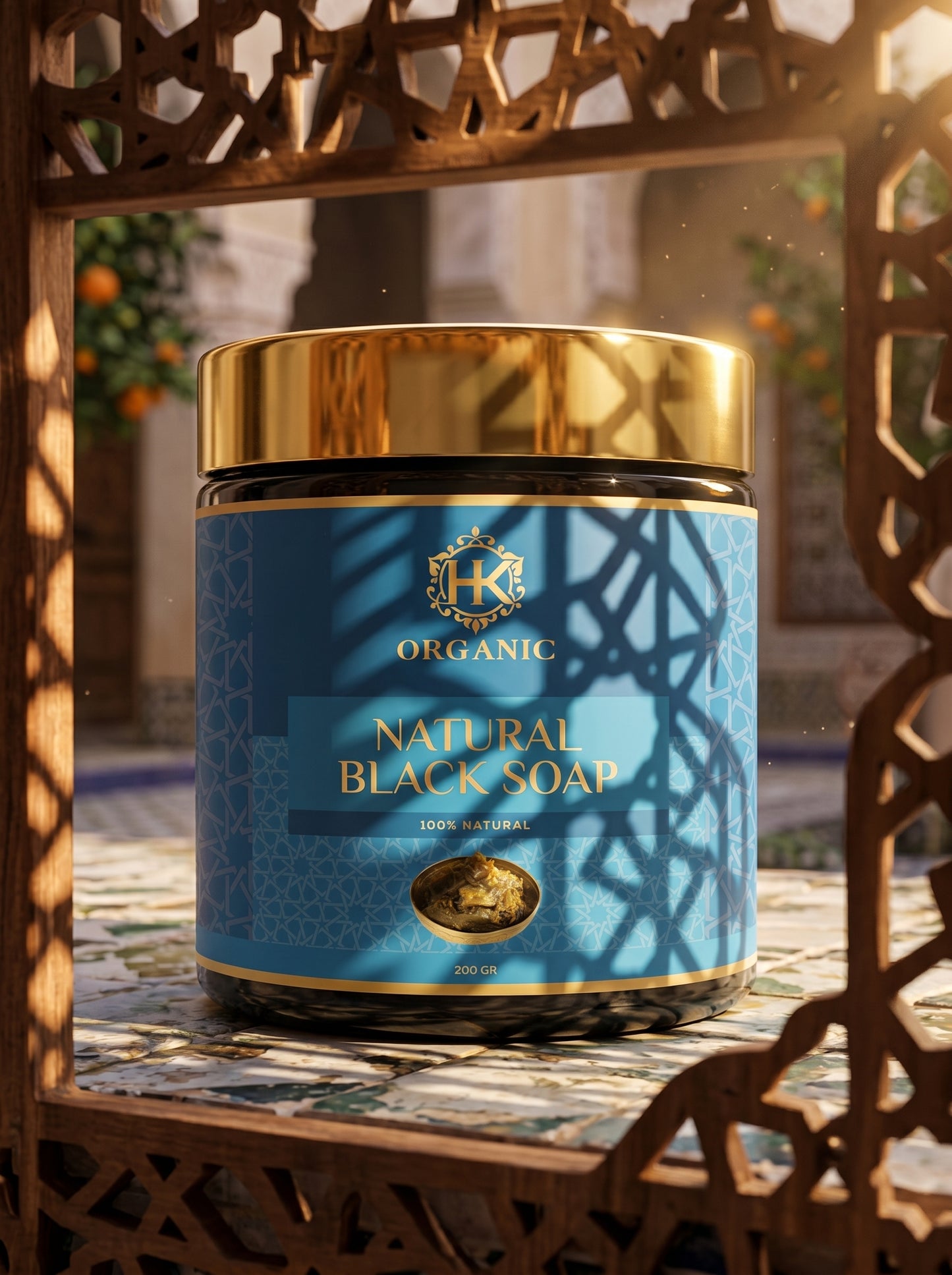 Jar of organic natural black soap with a blue label and gold accents on a decorative background.