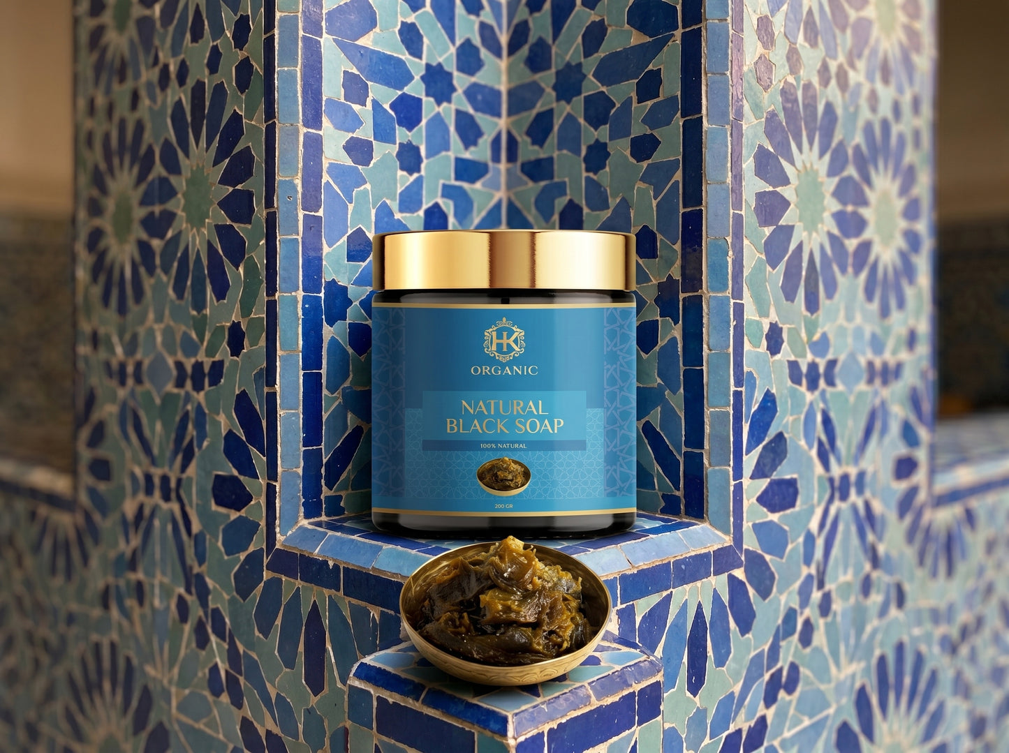 Jar of natural black soap on a blue tiled shelf