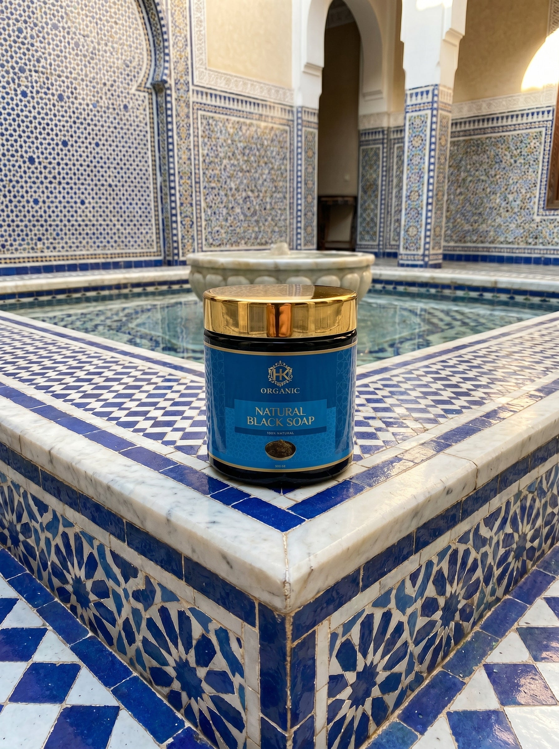 Blue and gold container of soap on a decorative tiled fountain