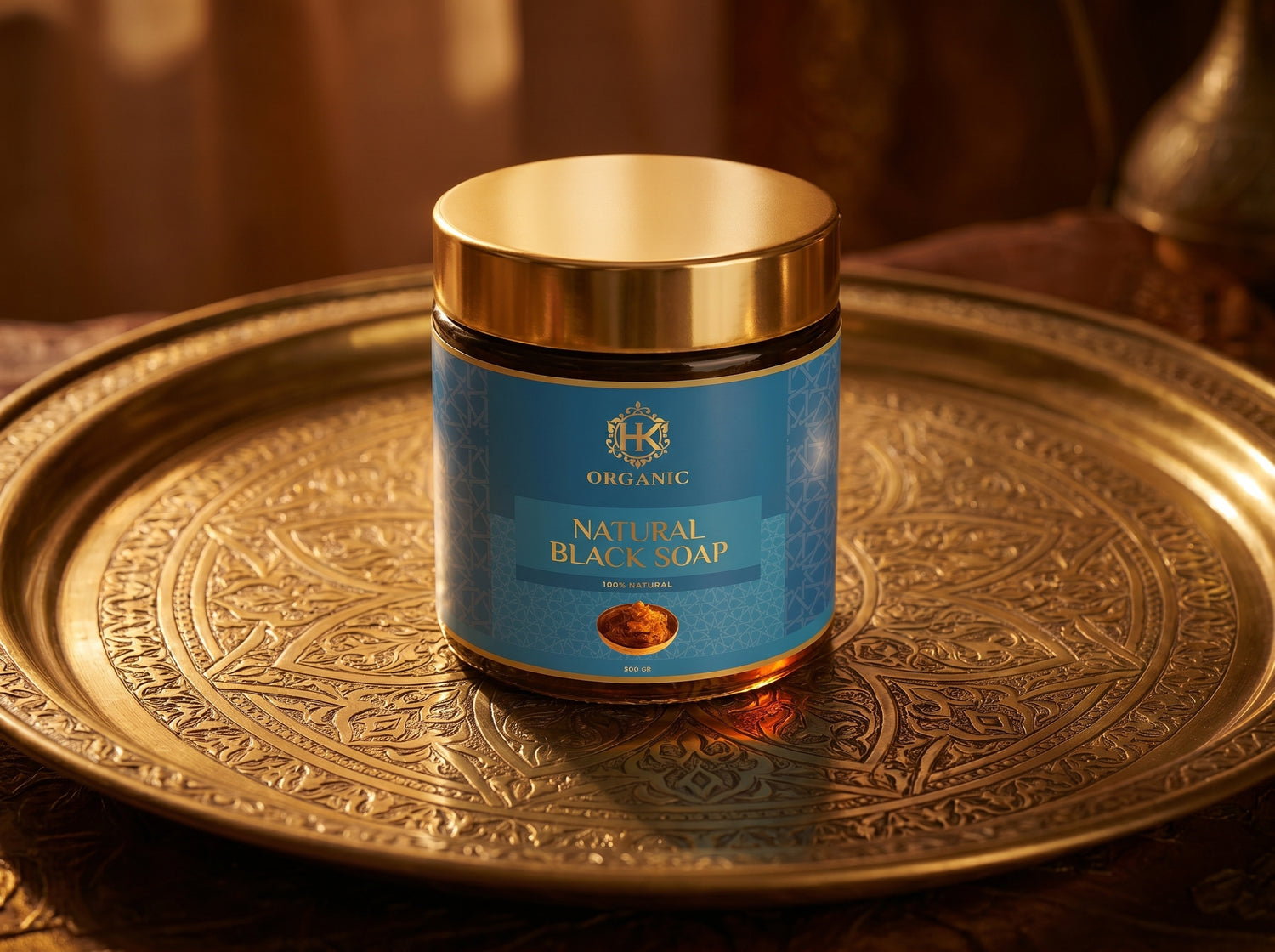 Jar of natural black soap on a decorative gold tray