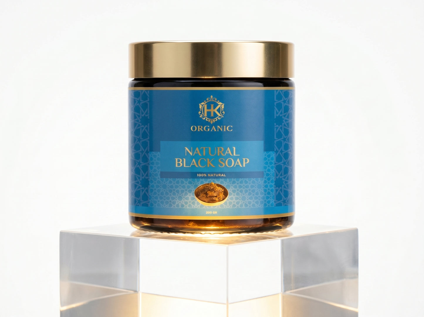 Jar of natural black soap with blue label and gold accents on a white background