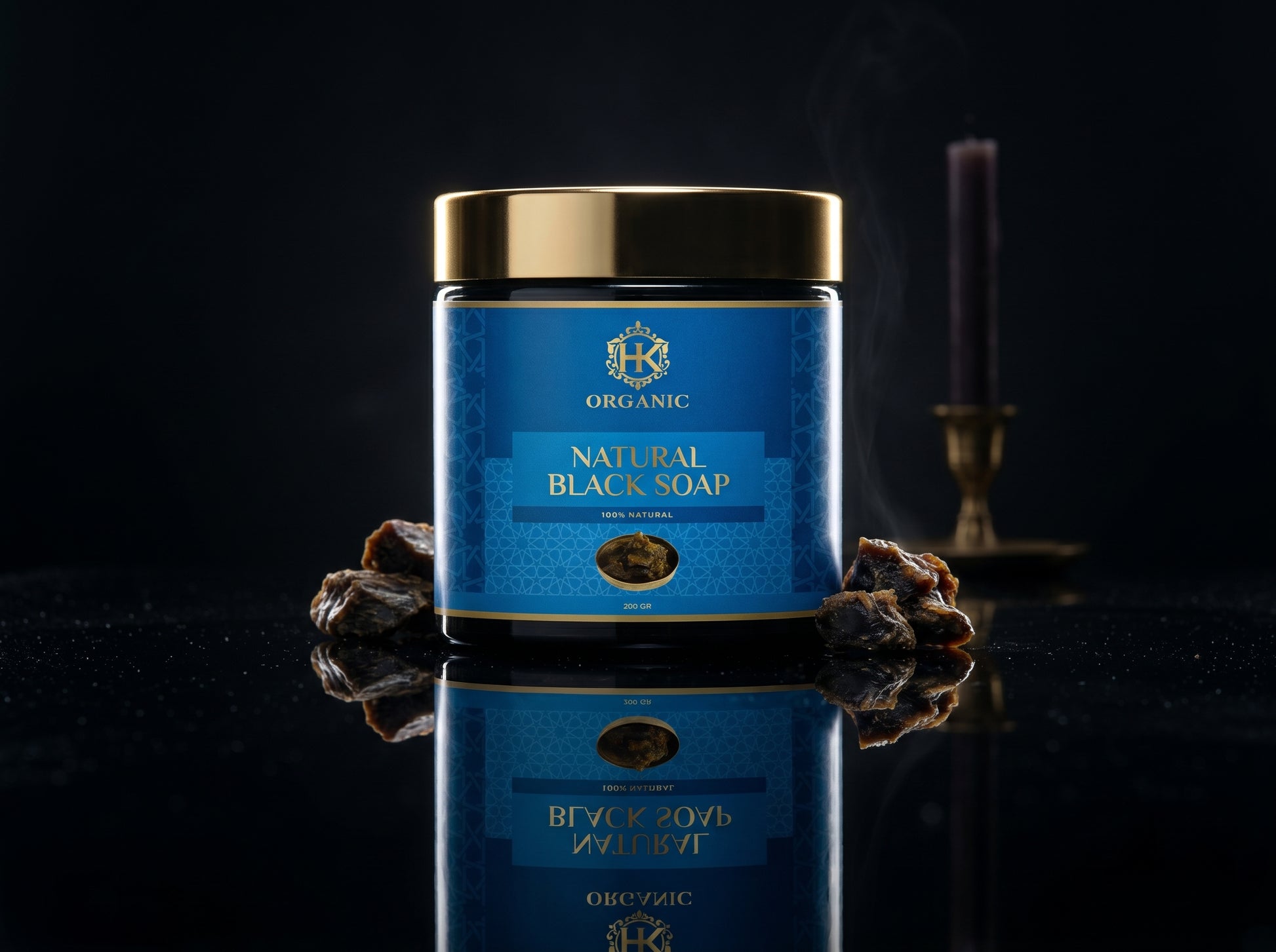 Jar of natural black soap with a blue label on a reflective surface.