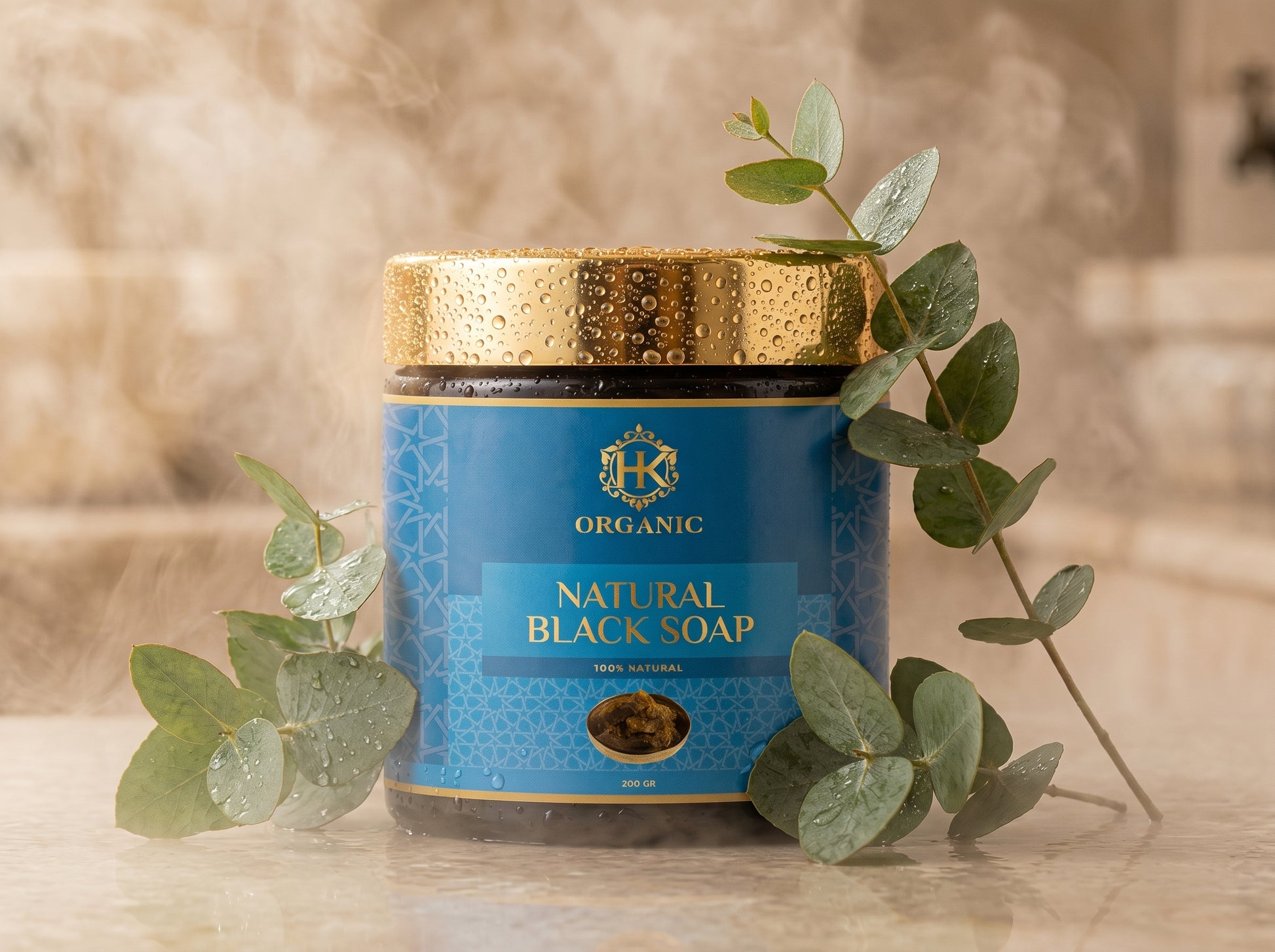 Jar of organic natural black soap with a gold lid on a neutral background