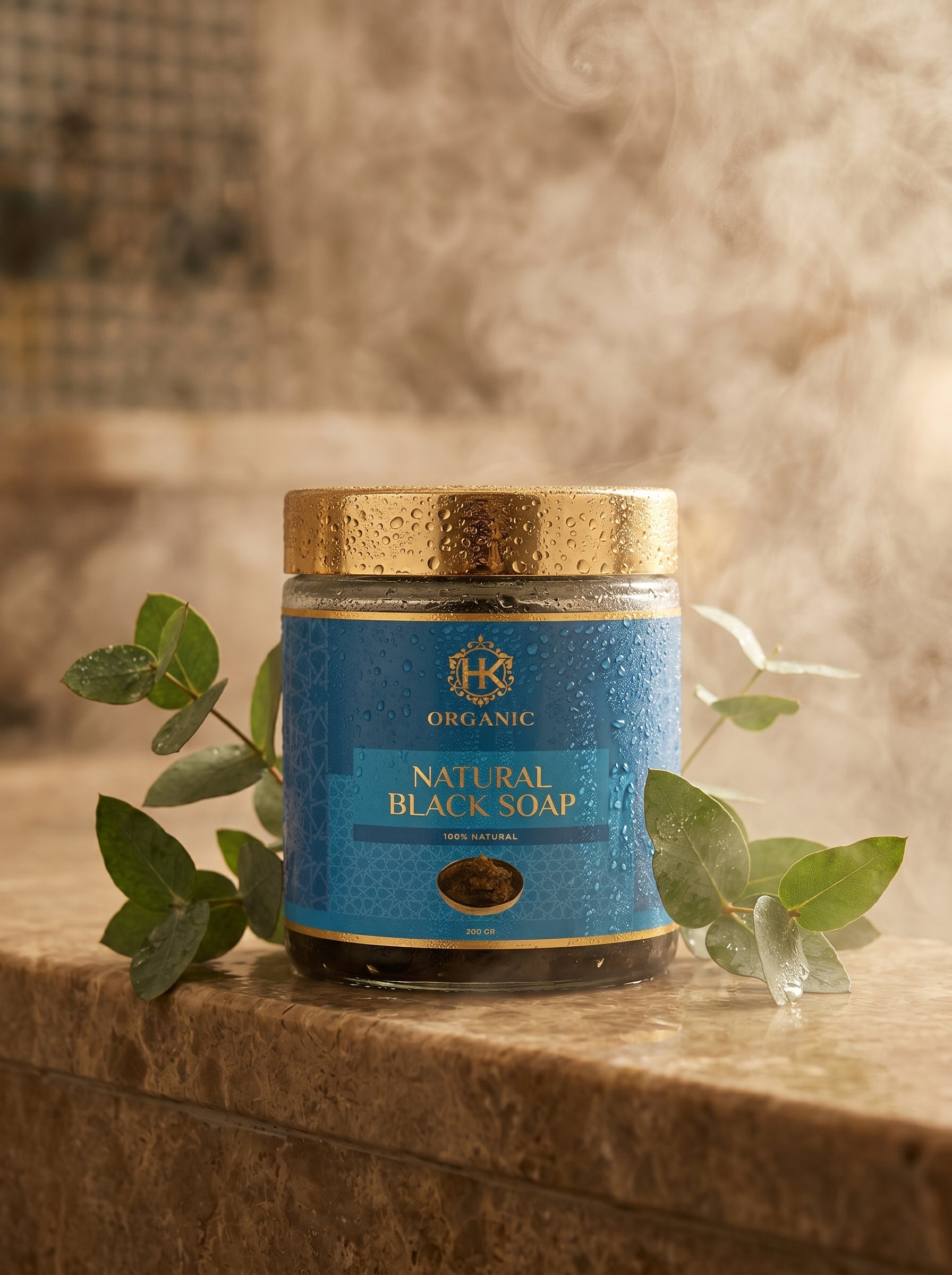 Jar of natural black soap with a gold lid on a wooden surface with eucalyptus leaves.