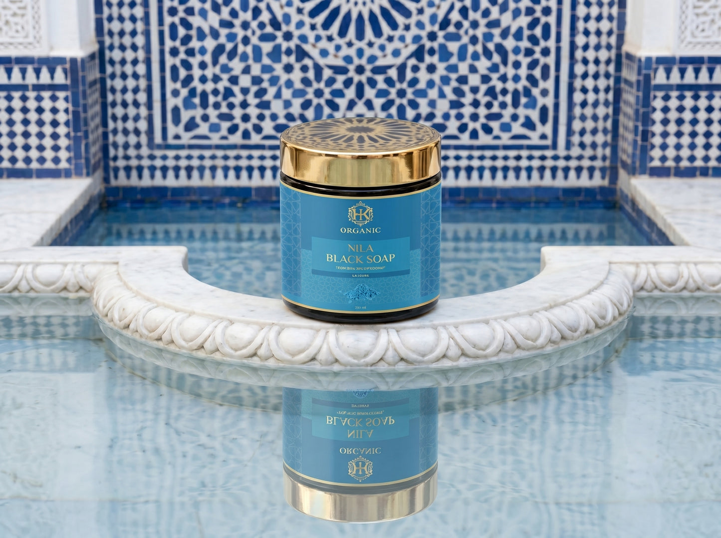 Blue and gold container of black soap on a decorative fountain with blue and white tiles.