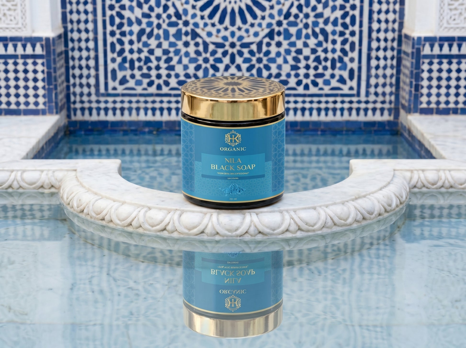 Blue and gold container of black soap on a decorative fountain with blue and white tiles.