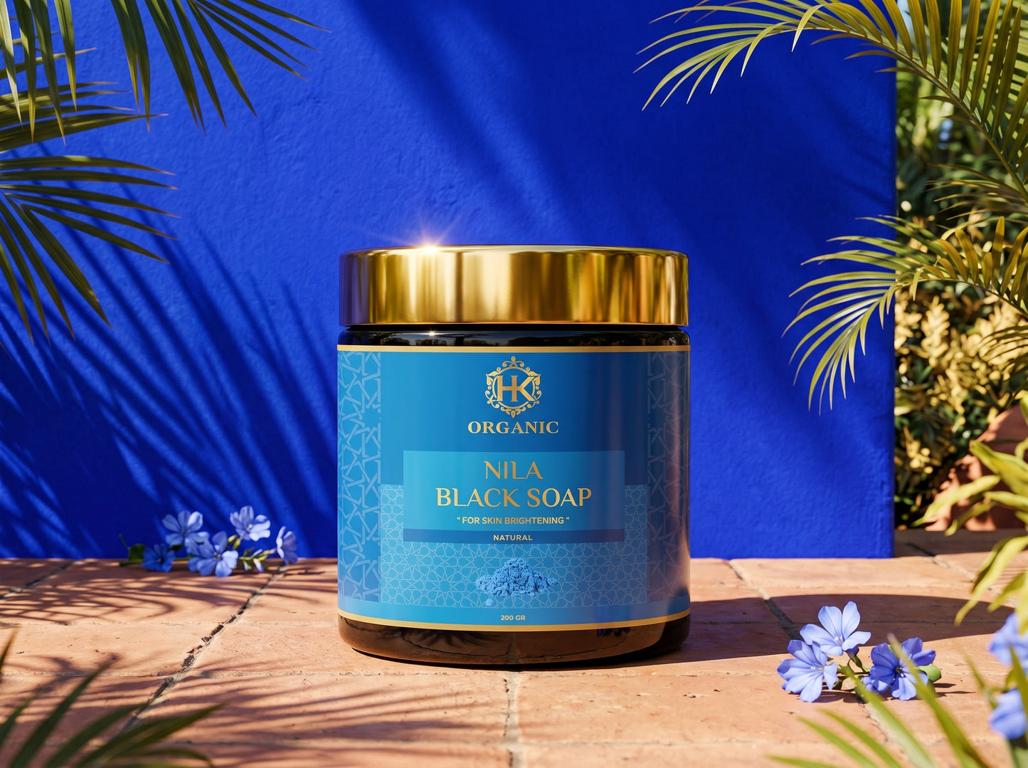Jar of Nila Black Soap with a blue label against a blue background with green foliage.