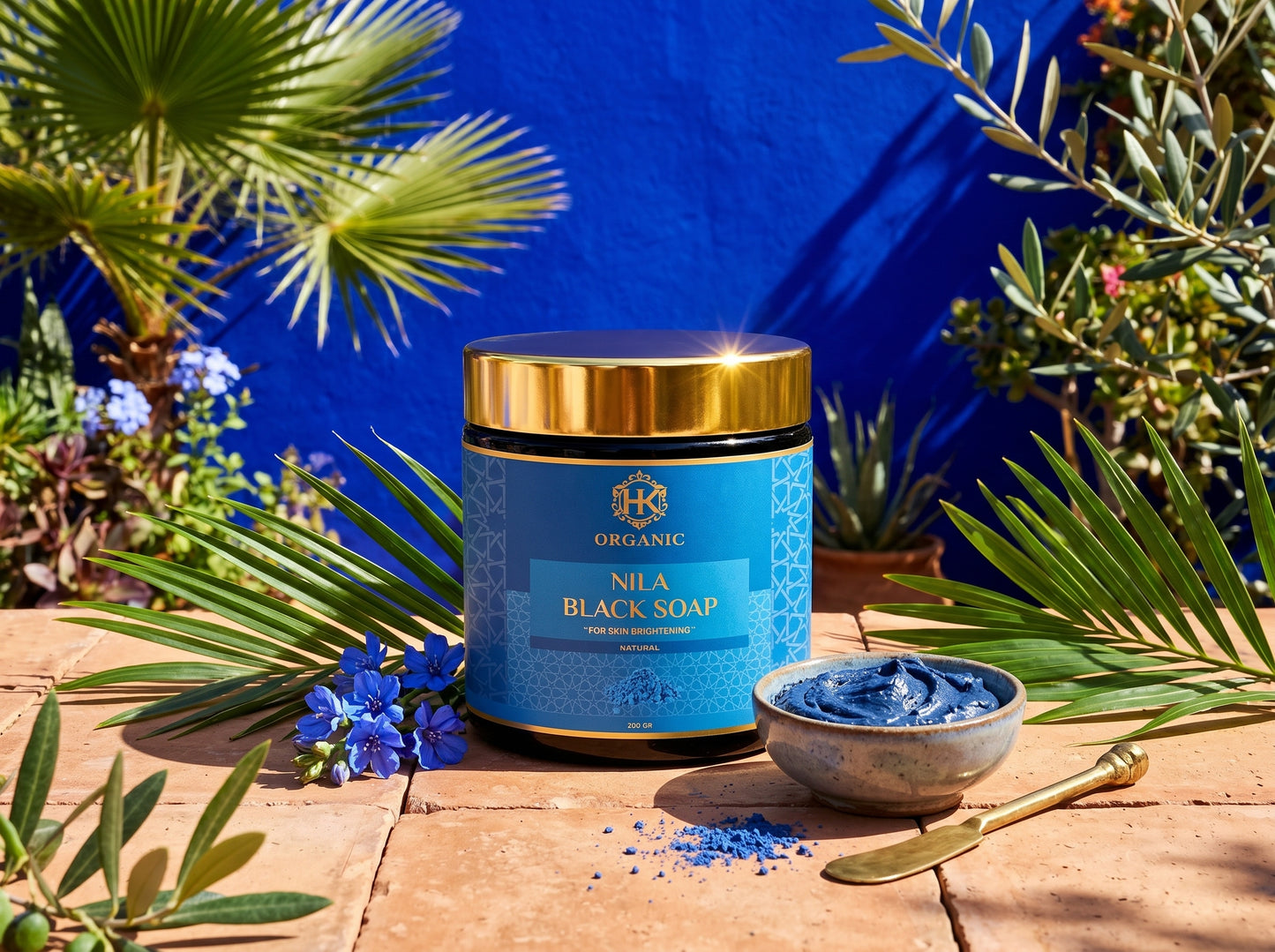 Nila Black Soap container with a blue label and gold lid on a wooden surface with greenery.