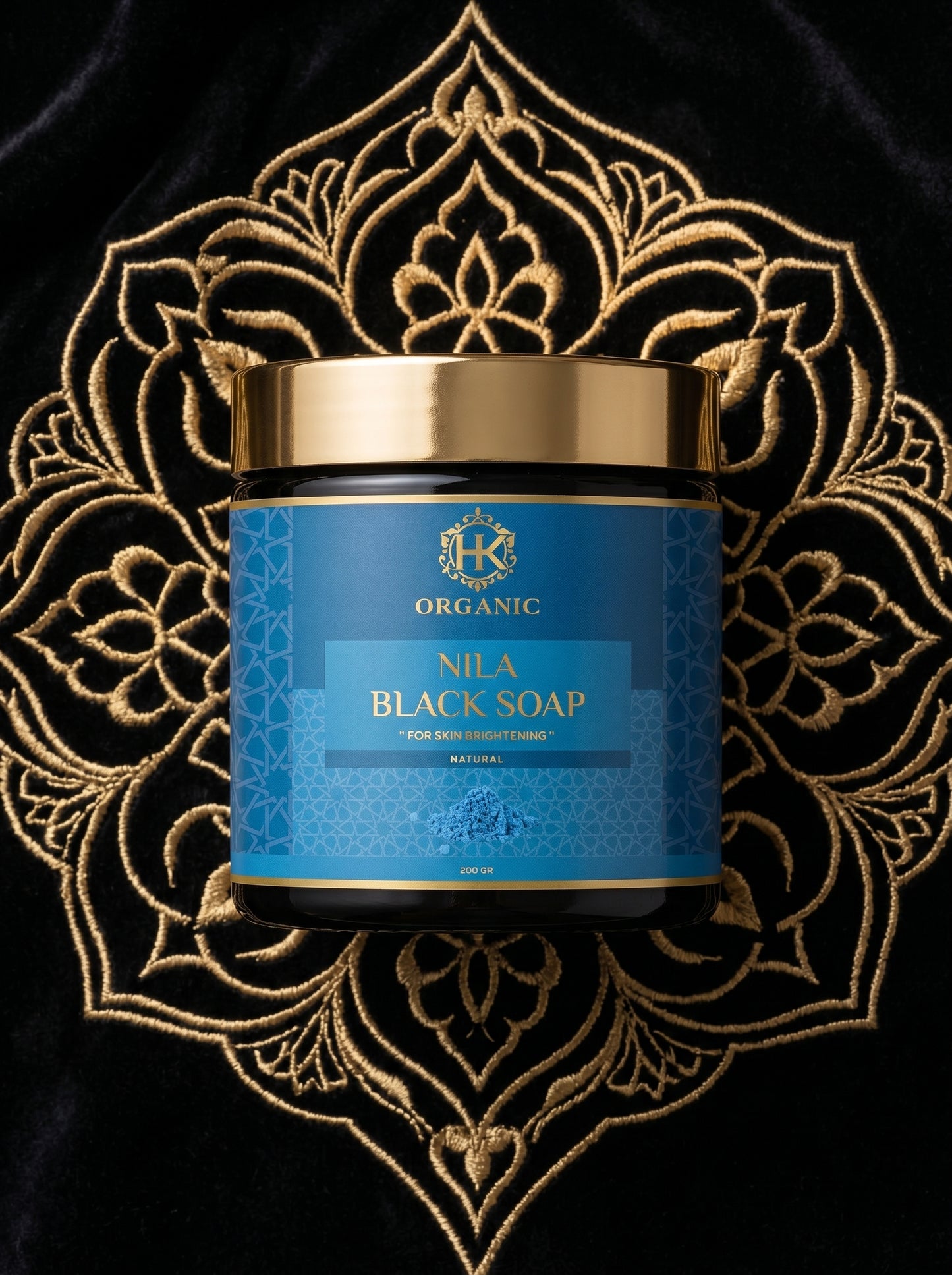 Jar of Nila Black Soap with decorative gold pattern on a black background