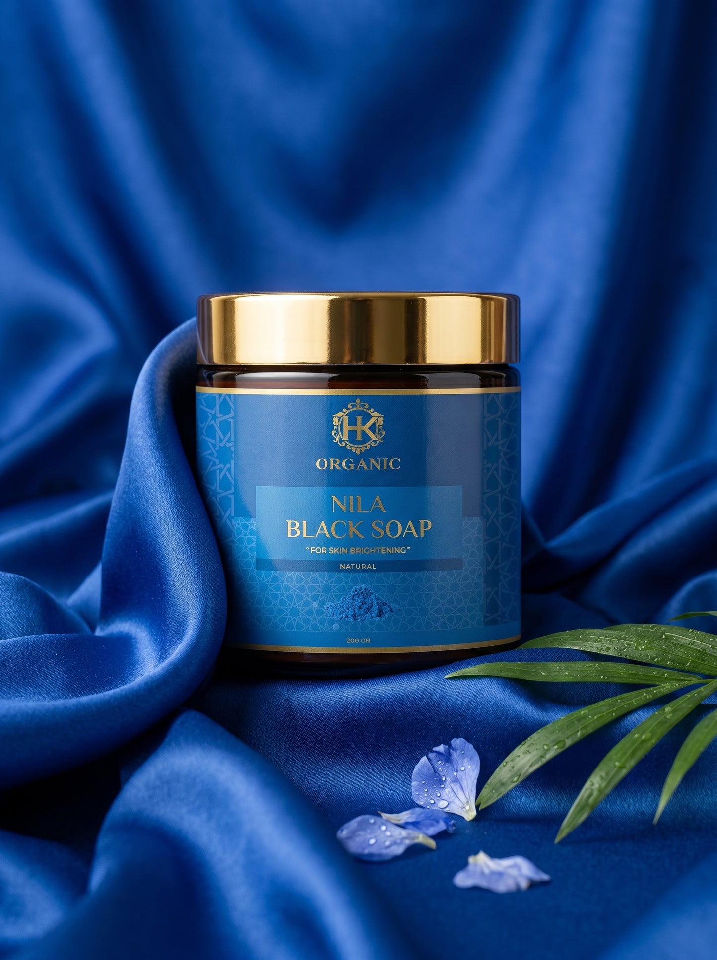 Blue jar of Nia A Black Soap with gold lid on a blue fabric background