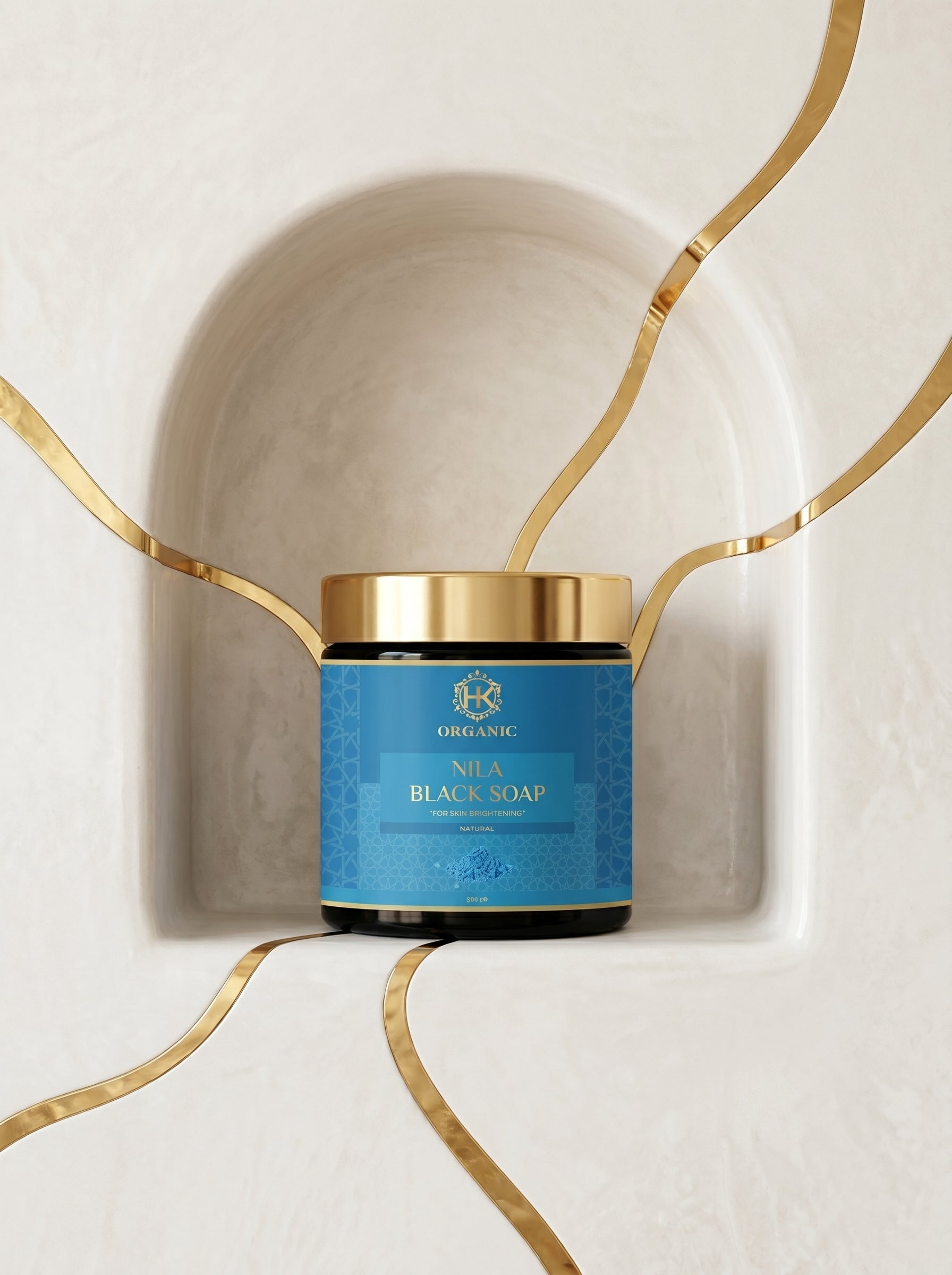 Blue jar of Neia Black Soap with gold lid on a decorative white and gold background
