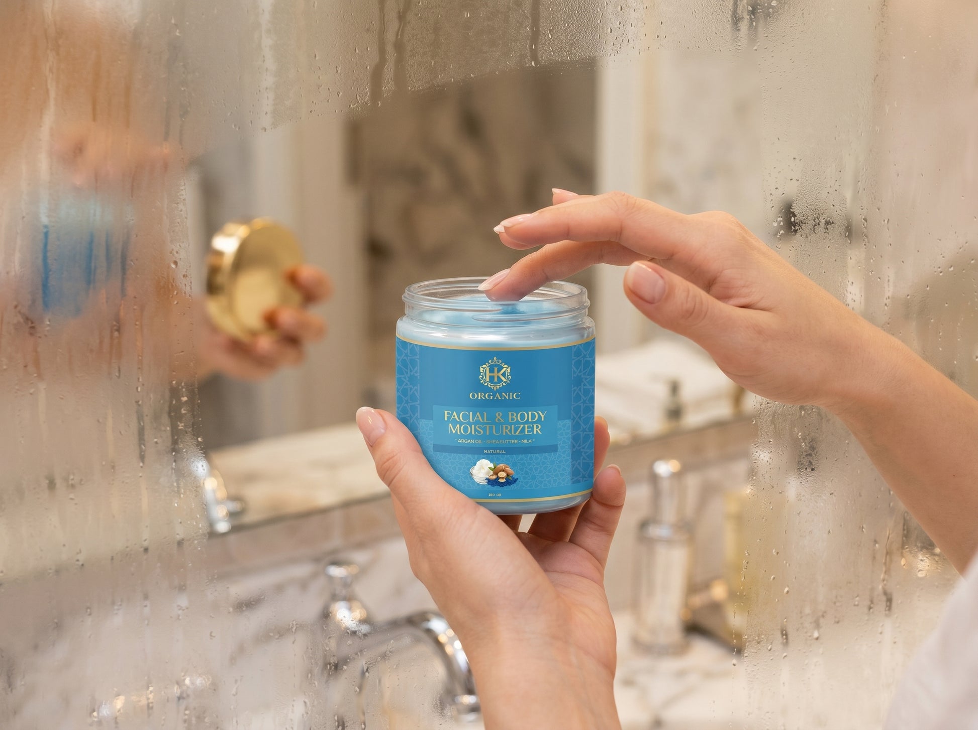 Person holding a jar of face cream in front of a bathroom mirror