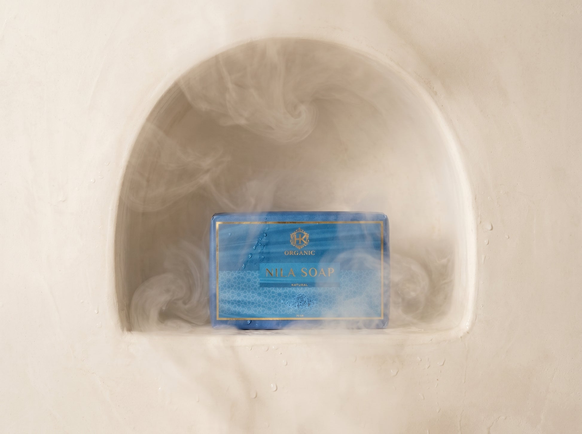 Bar of soap with a label in a clear dish on a white background