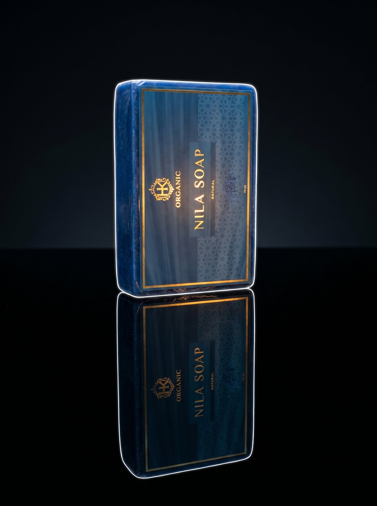 Nila Soap bar with blue packaging on a reflective black surface