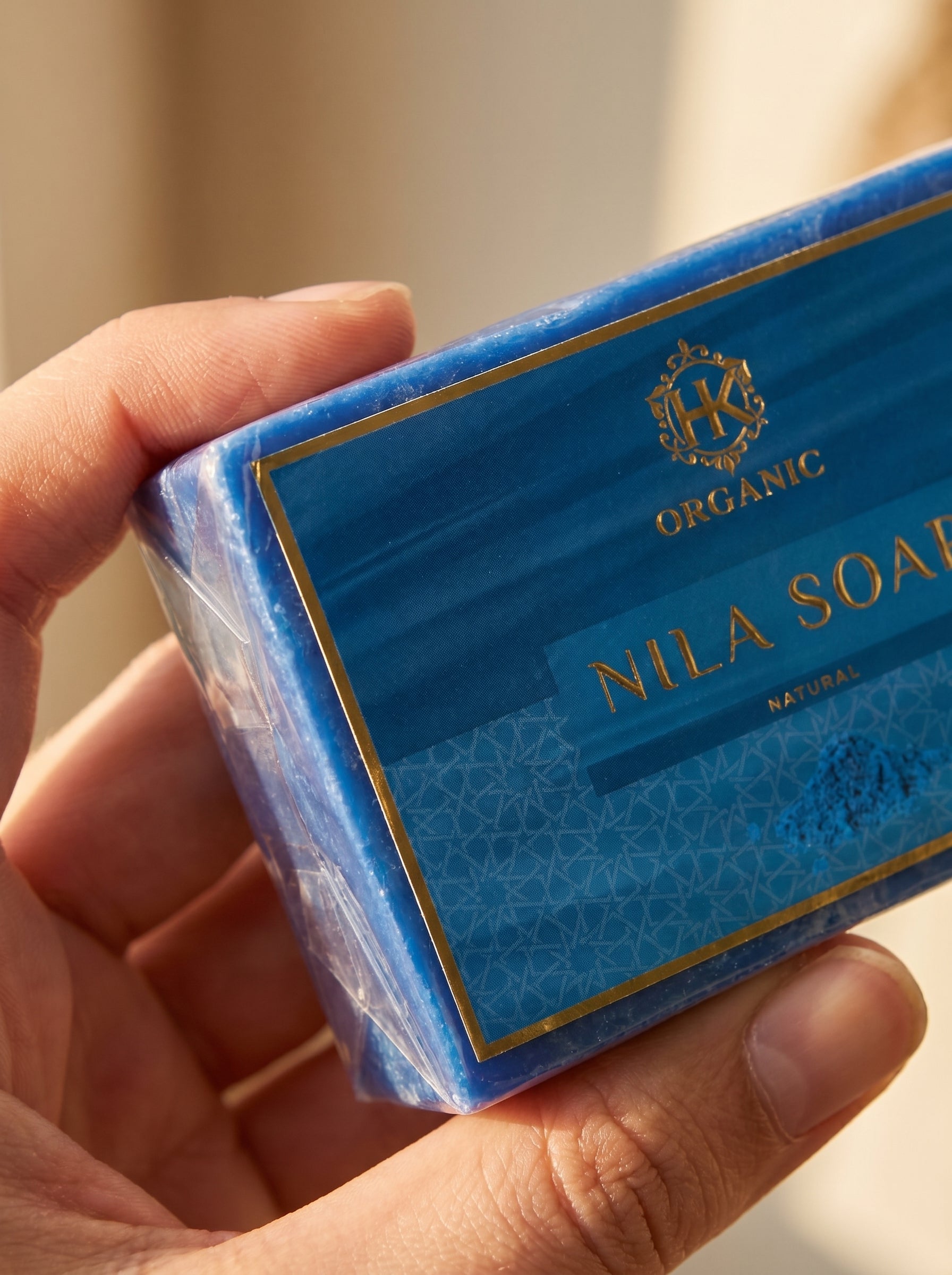 Hand holding a blue Nila Soap packaging with visible branding.