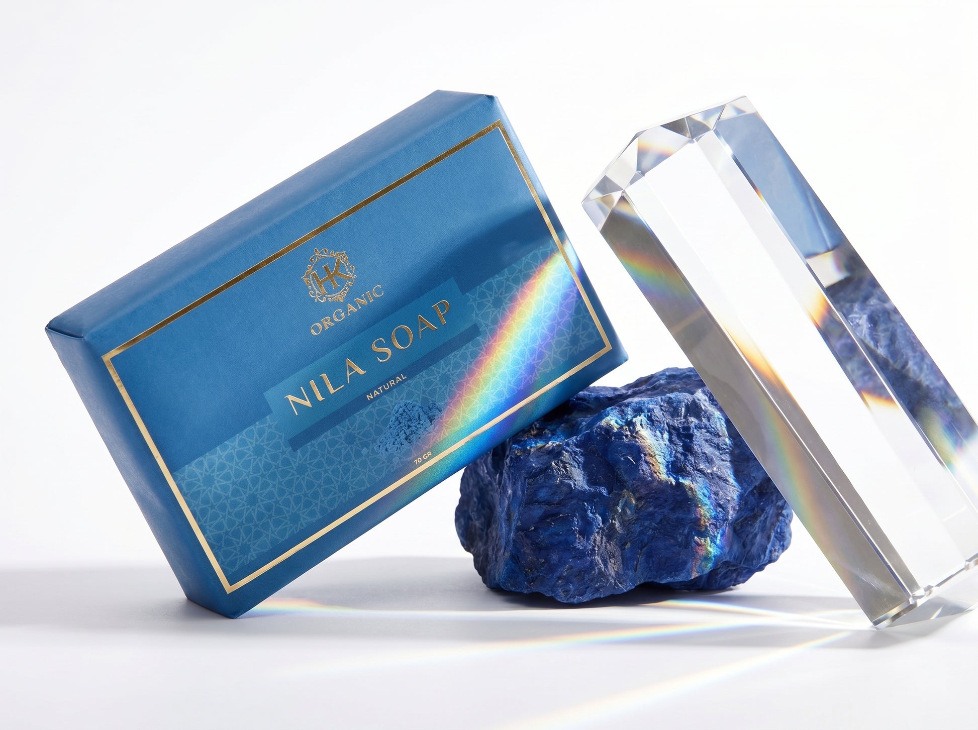 Blue Nila Soap bar with a rainbow effect, next to a crystal and a blue stone on a white background.
