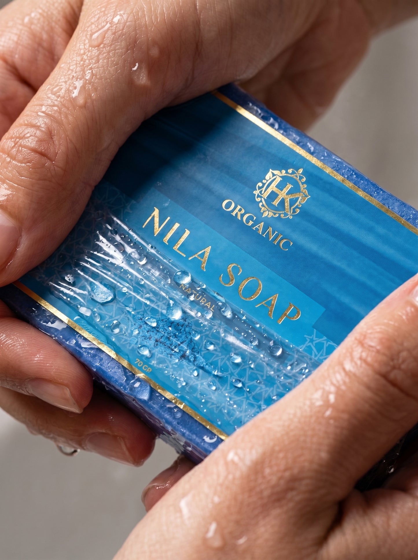 Hands holding a blue box of Nila Soap with visible branding.
