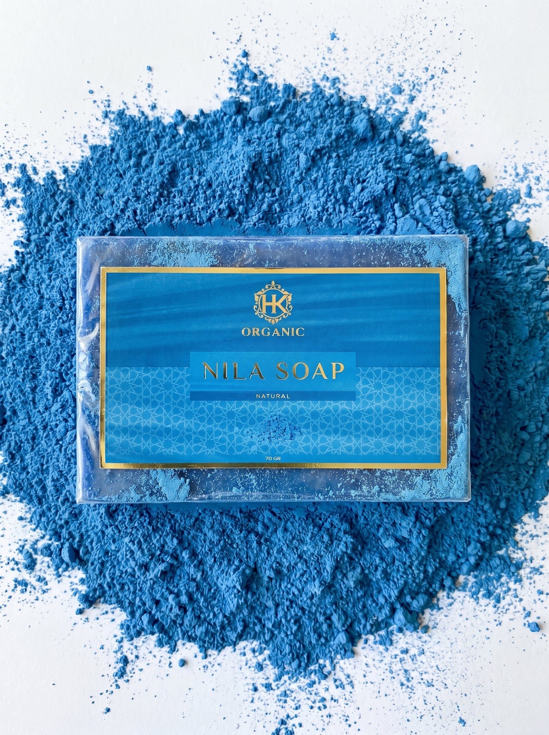 Nila Soap bar with blue powder around it on a light background