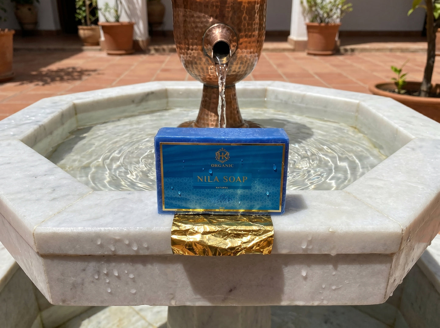 Nila Soap bar on a marble fountain with a decorative copper spout.