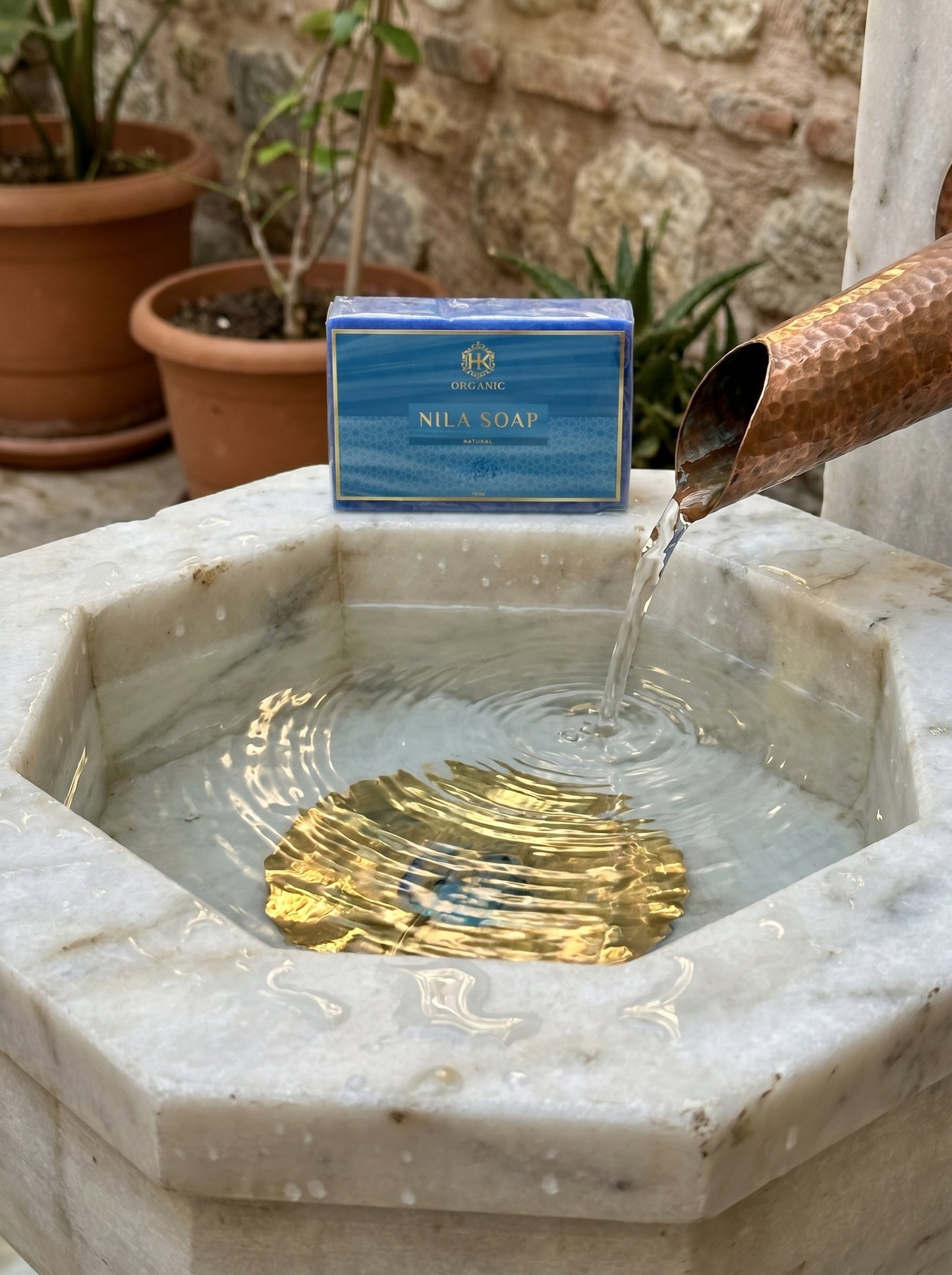 Nila Soap bar on a marble fountain with water flowing