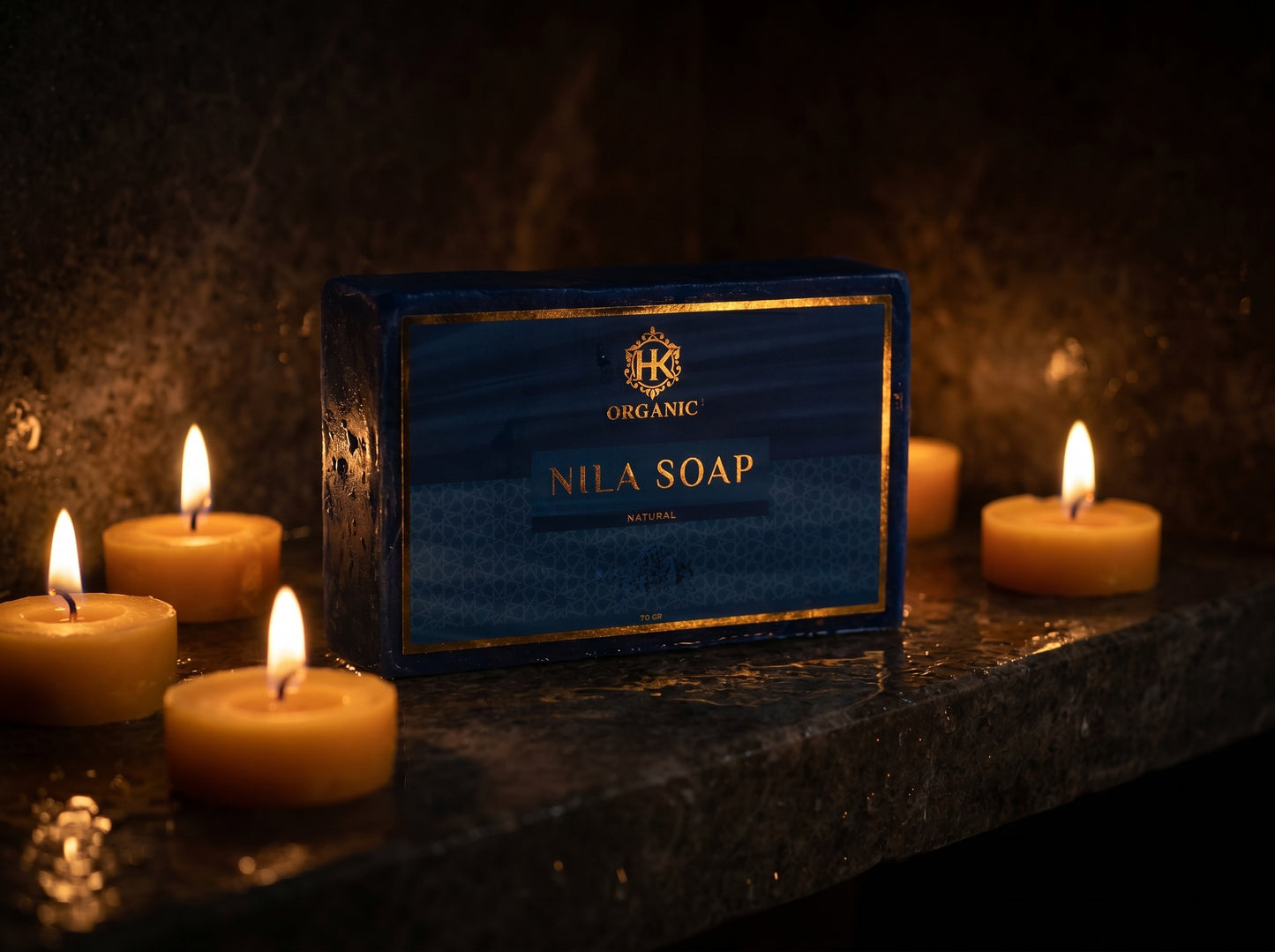 Box of Nila Soap with lit candles on a dark surface