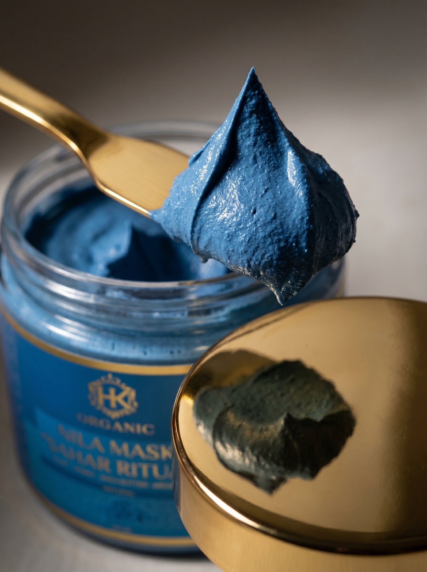 Blue mask in a jar with a gold spoon and lid