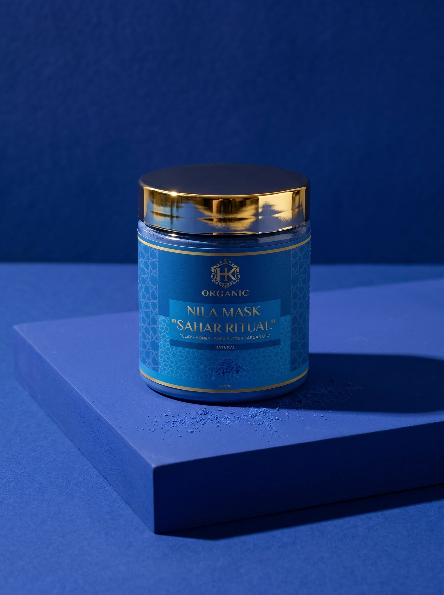 Blue jar with gold lid on a blue platform against a blue background