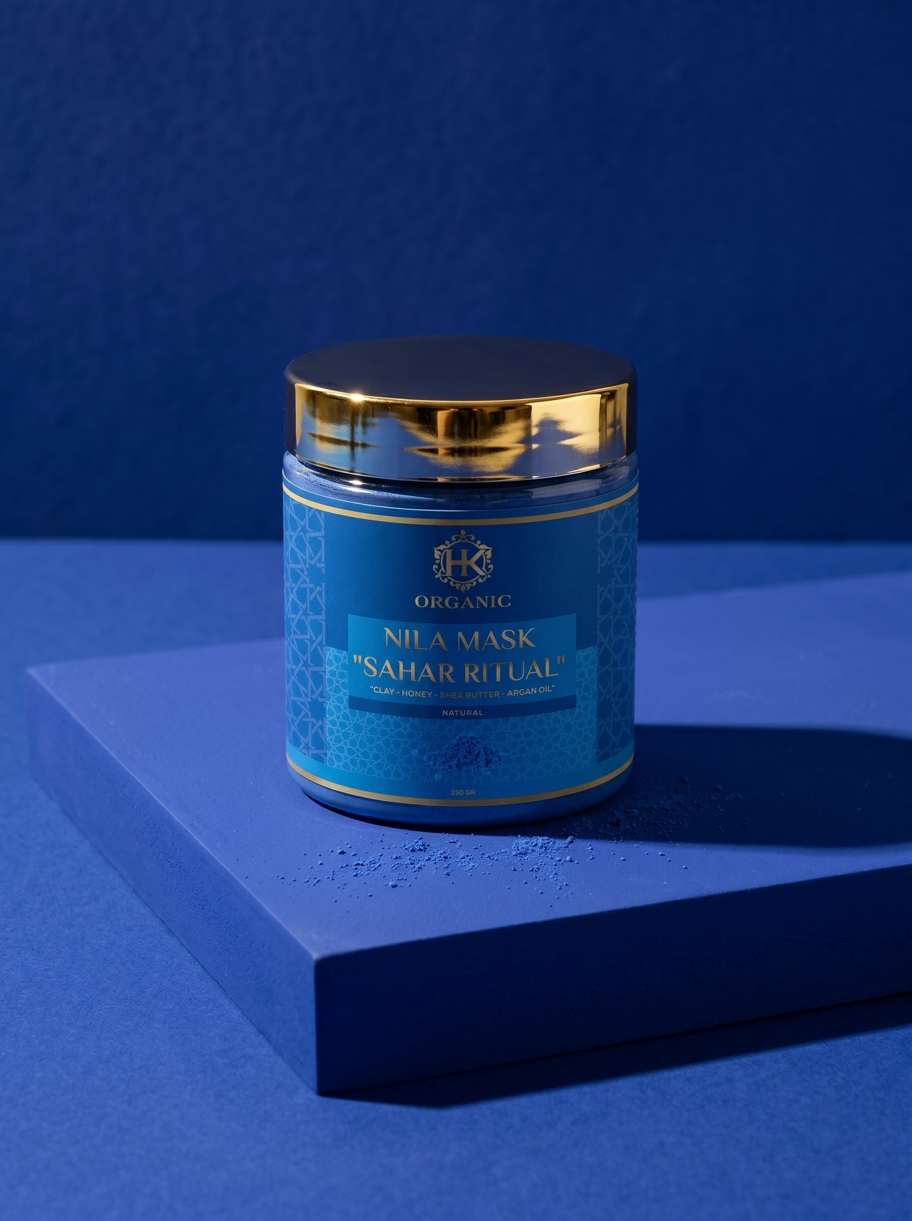 Blue jar with gold lid on a blue platform against a blue background