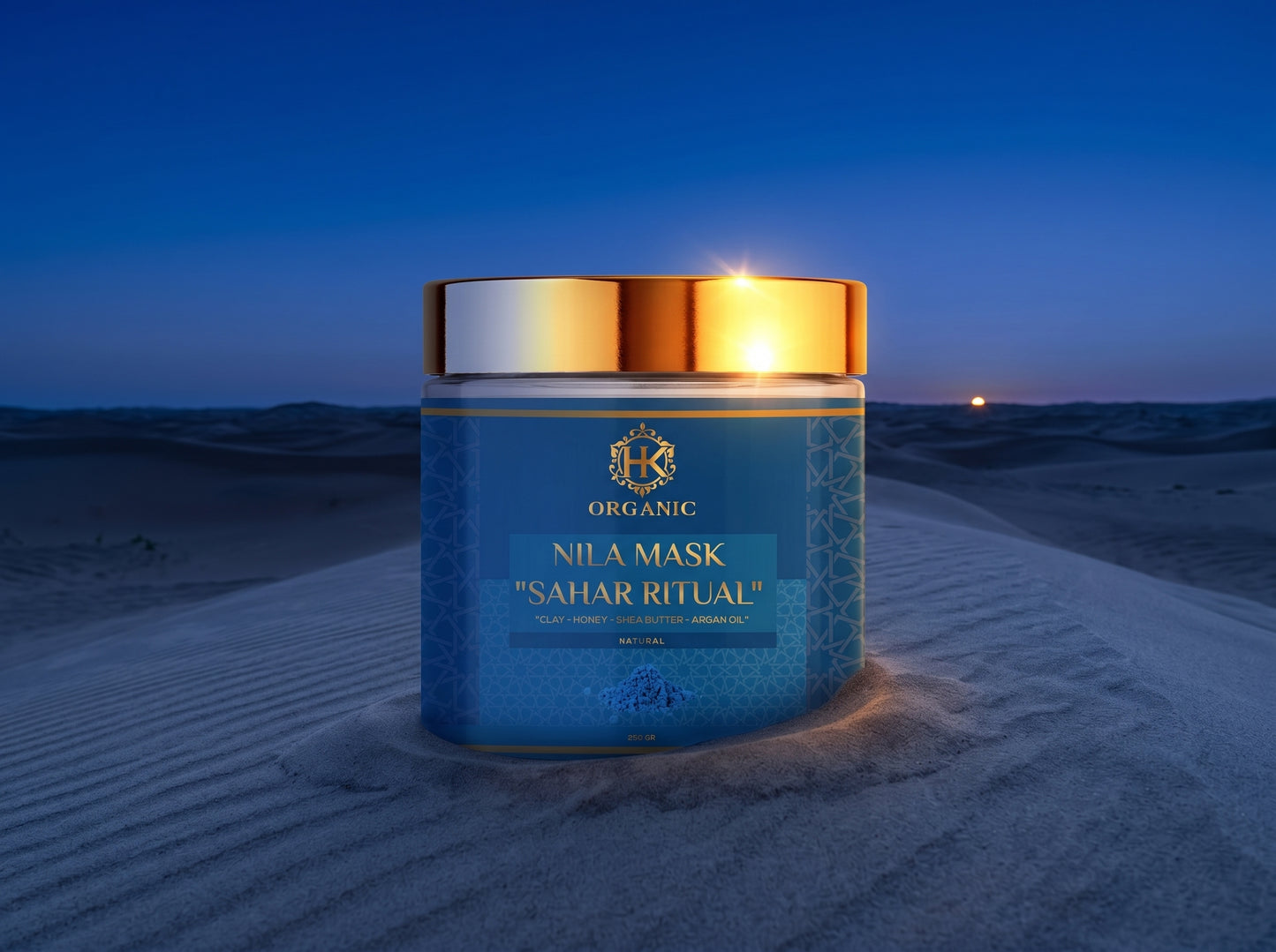 Blue jar of Organic Nila Mask 'Sahar Ritual' on a sand dune at night.