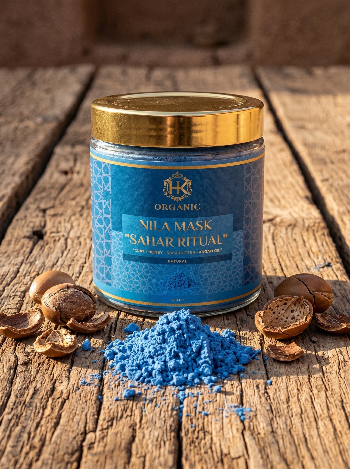 Blue powder with a jar labeled 'Nila Mask Sahar Ritual' on a wooden surface.