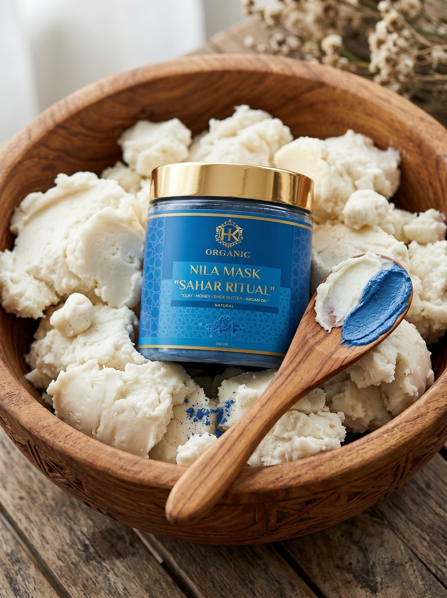 Blue jar of Nila Mask in a wooden bowl with cauliflower and a wooden spoon.