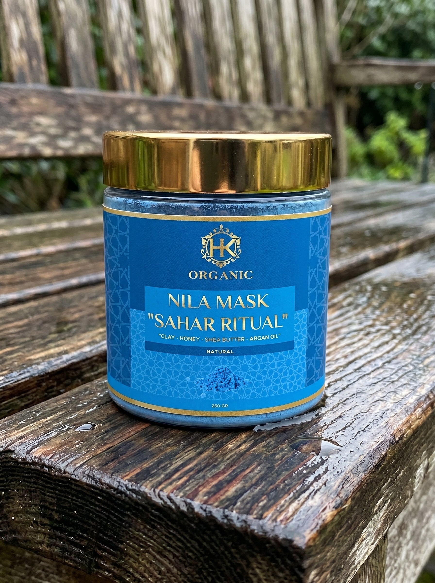 Blue jar with gold lid labeled 'Nila Mask Sahar Ritual' on a wooden surface