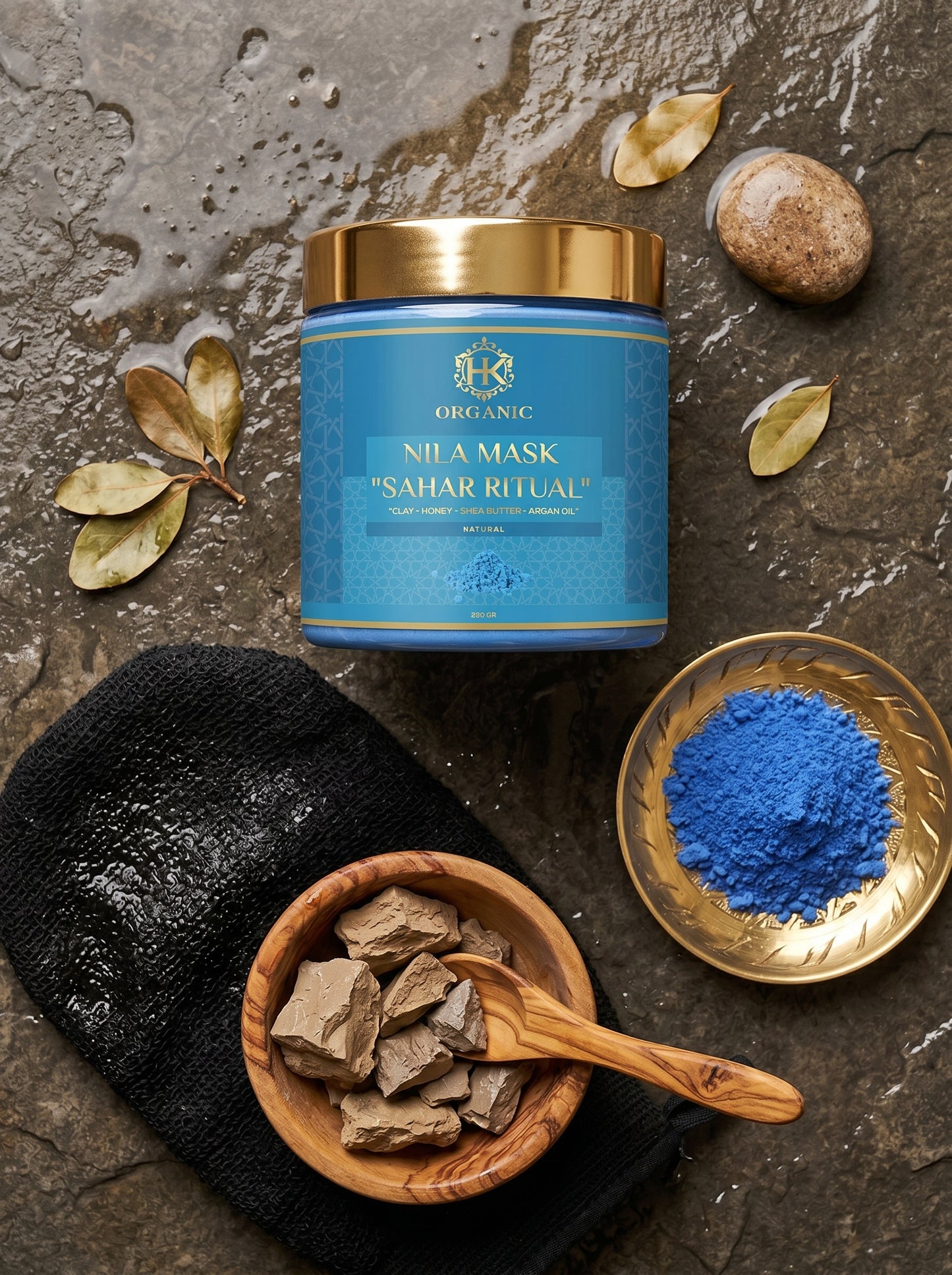 Nila Mask container with blue powder, black mask, and brown stones on a stone surface