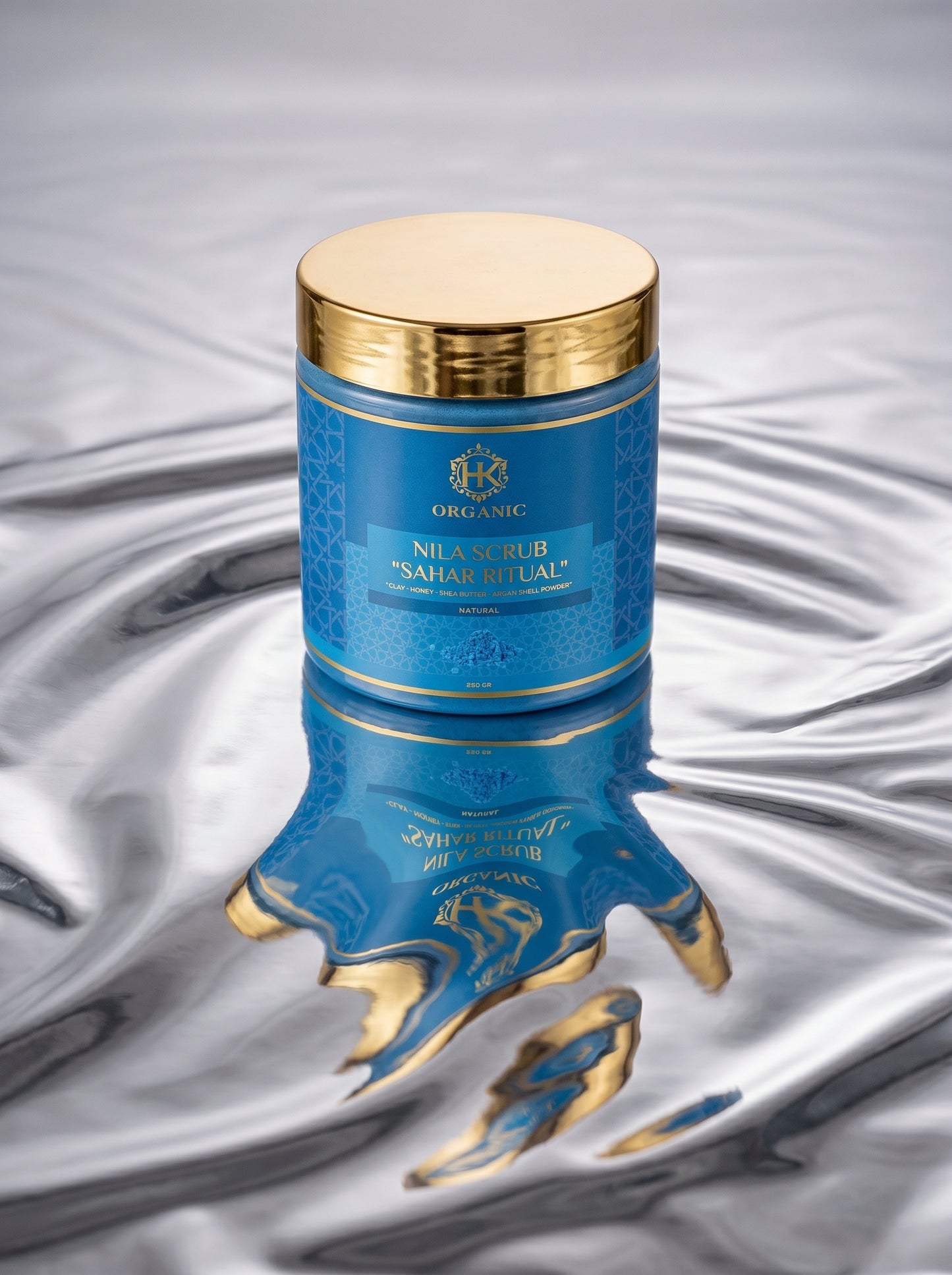 Blue and gold cosmetic container with intricate design on a textured gray background