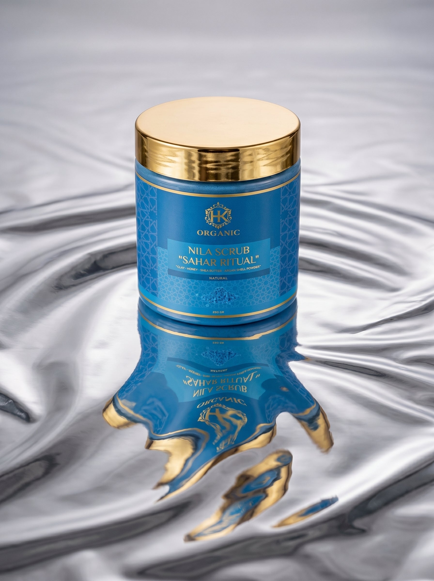 Blue and gold cosmetic container with intricate design on a textured gray background