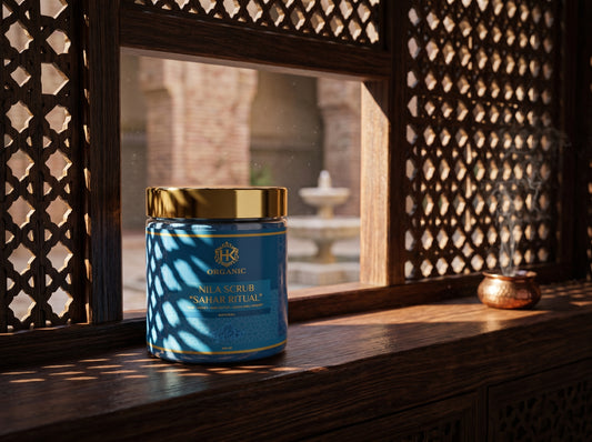 Blue jar with gold lid on a wooden surface with a decorative window in the background