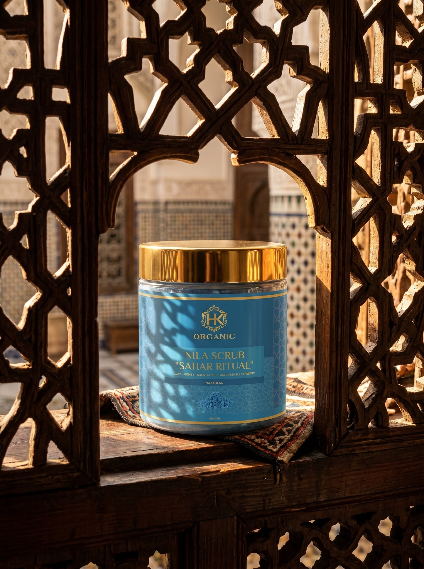 Blue container with gold lid on a wooden surface, framed by decorative wooden lattice