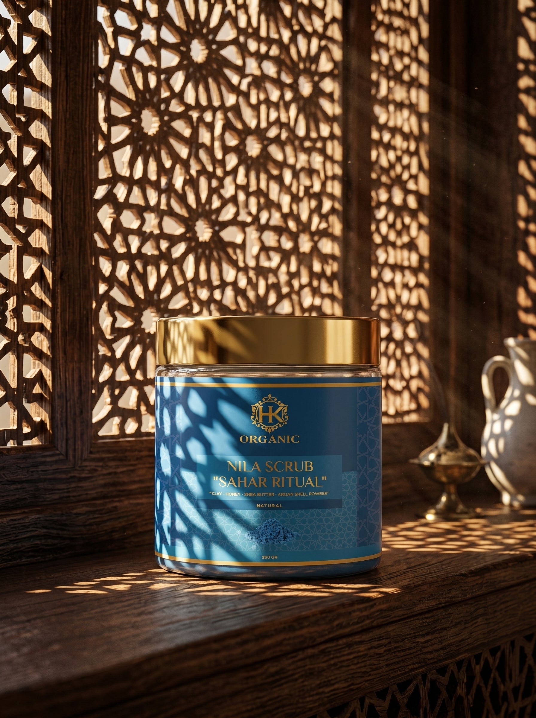 Blue jar of organic nila scrub with gold lid on a wooden surface with decorative background